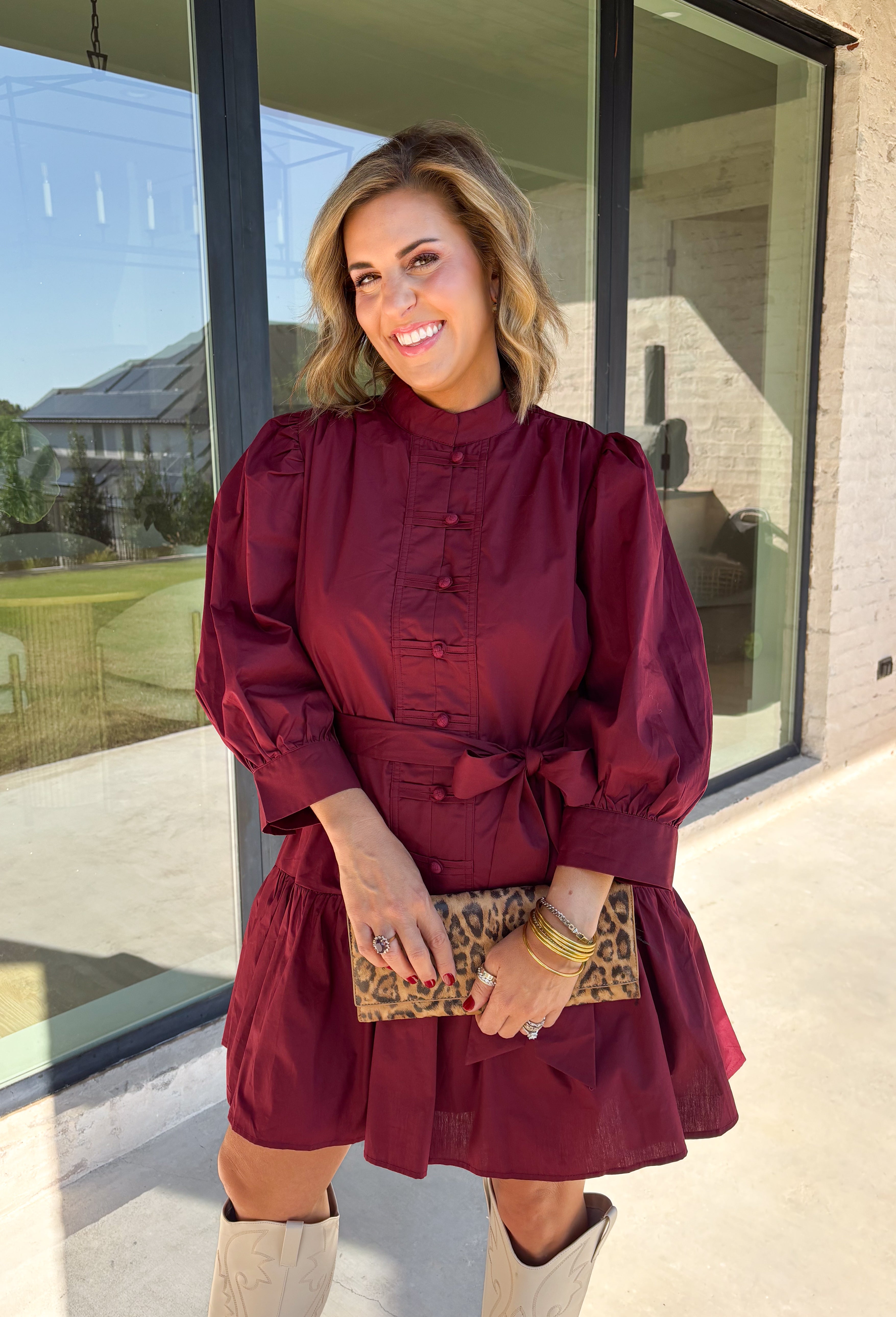 Rich burgundy makes this dress from Entro an easy favorite for all the plans filling up your fall calendar. The stand collar and split neckline create a classic look, while the button-front closure adds a pretty finishing detail. Long balloon sleeves bring soft volume to the silhouette and are finished with button cuffs for a more tailored touch. A removable self-tie belt lets you define the waist or switch up the look, while the tiered skirt adds movement and shape. 