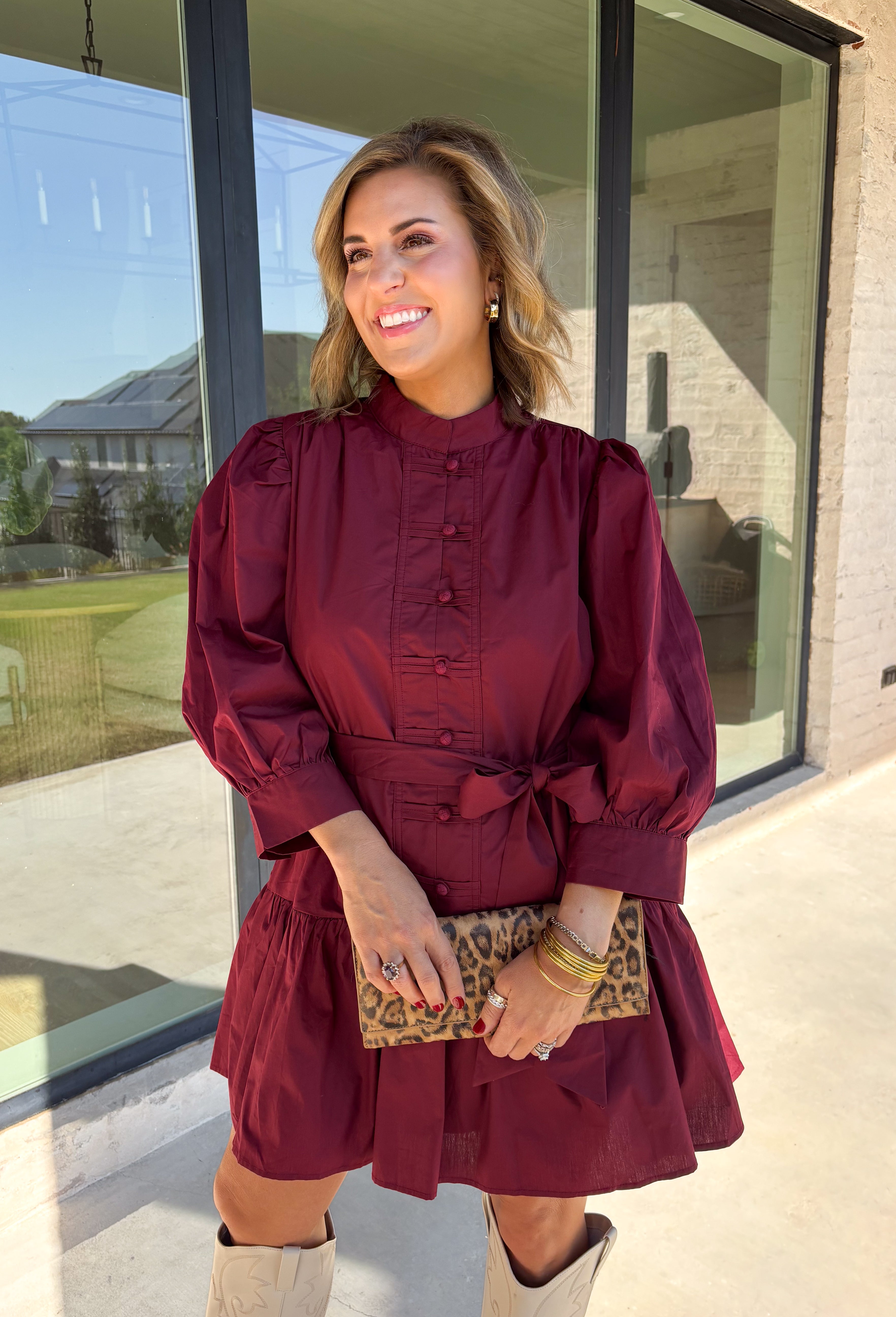 Rich burgundy makes this dress from Entro an easy favorite for all the plans filling up your fall calendar. The stand collar and split neckline create a classic look, while the button-front closure adds a pretty finishing detail. Long balloon sleeves bring soft volume to the silhouette and are finished with button cuffs for a more tailored touch. A removable self-tie belt lets you define the waist or switch up the look, while the tiered skirt adds movement and shape. 