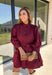 Rich burgundy makes this dress from Entro an easy favorite for all the plans filling up your fall calendar. The stand collar and split neckline create a classic look, while the button-front closure adds a pretty finishing detail. Long balloon sleeves bring soft volume to the silhouette and are finished with button cuffs for a more tailored touch. A removable self-tie belt lets you define the waist or switch up the look, while the tiered skirt adds movement and shape. 