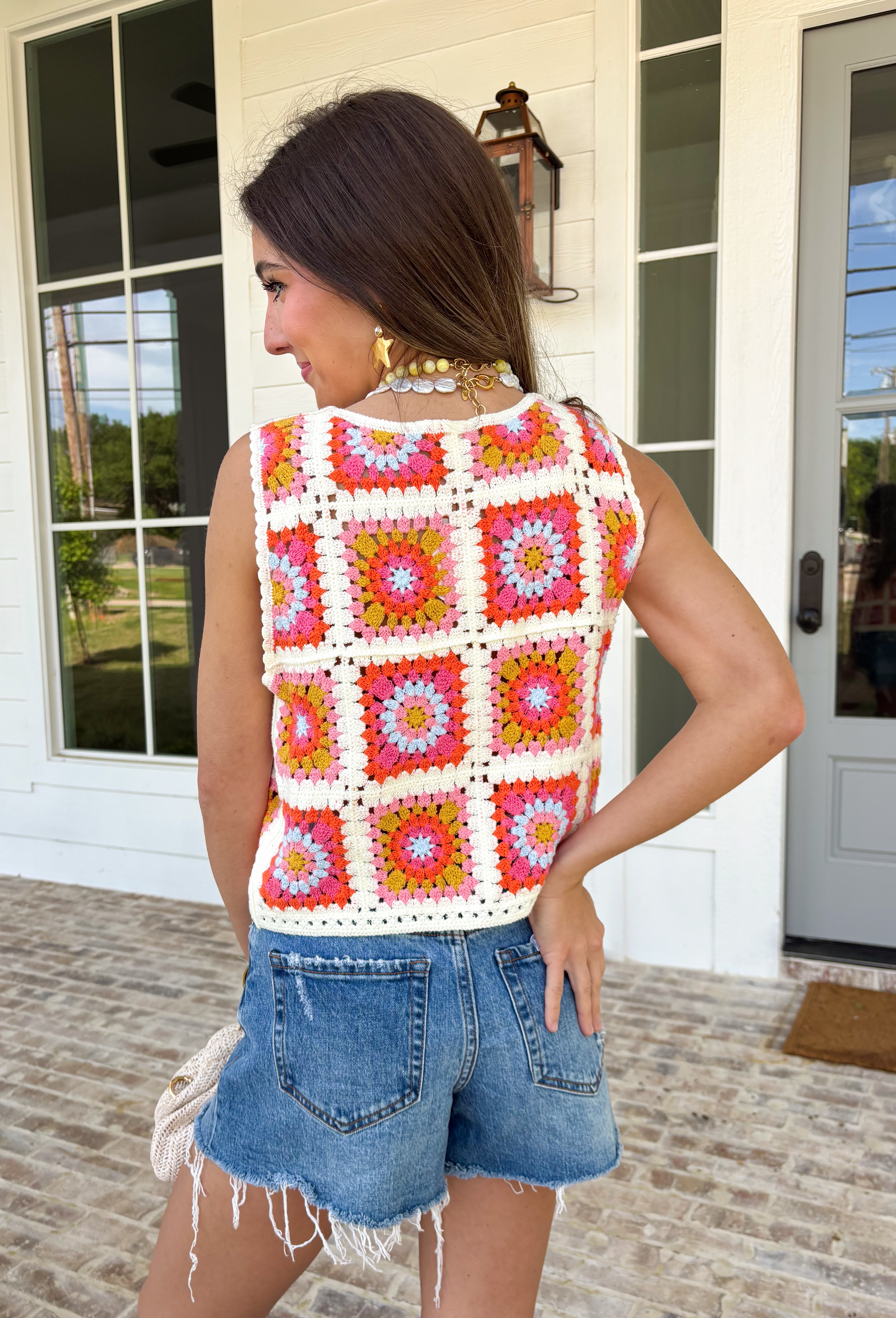 This sleeveless crochet lace embroidered top is bringing all the vibrant, sunshine-ready energy. Designed with a colorful mix of off white, orange, pink, blue, and mustard, it’s the kind of piece that instantly makes an outfit feel fun and fresh. The intricate crochet lace and embroidered details give it that handcrafted look we love, while the button-down front keeps it classic and easy to style. With its cropped length, it pairs perfectly with high-rise denim, skirts, or shorts.