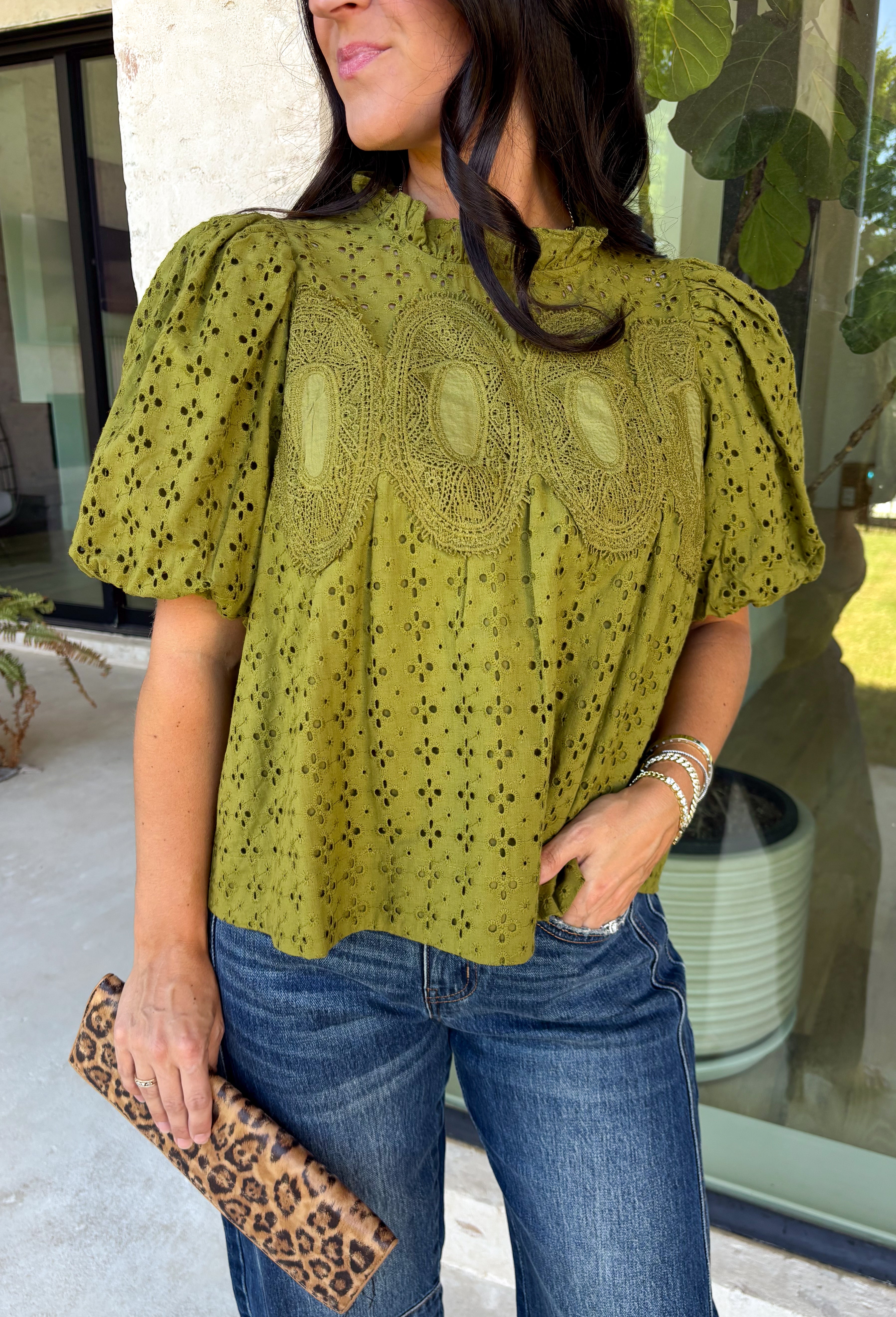 Pretty details make this olive top from Entro one you'll want to work into your fall rotation. The rich olive shade feels perfect for the season, while eyelet detailing and crochet trim add texture and interest to the solid design. A ruffled neckline brings a sweet finishing touch, and short puff sleeves give the silhouette just the right amount of shape. 