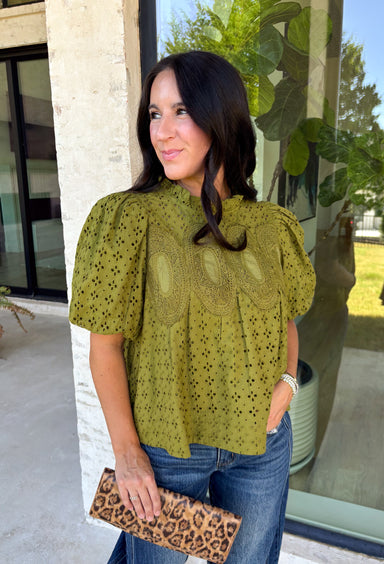 Pretty details make this olive top from Entro one you'll want to work into your fall rotation. The rich olive shade feels perfect for the season, while eyelet detailing and crochet trim add texture and interest to the solid design. A ruffled neckline brings a sweet finishing touch, and short puff sleeves give the silhouette just the right amount of shape. 