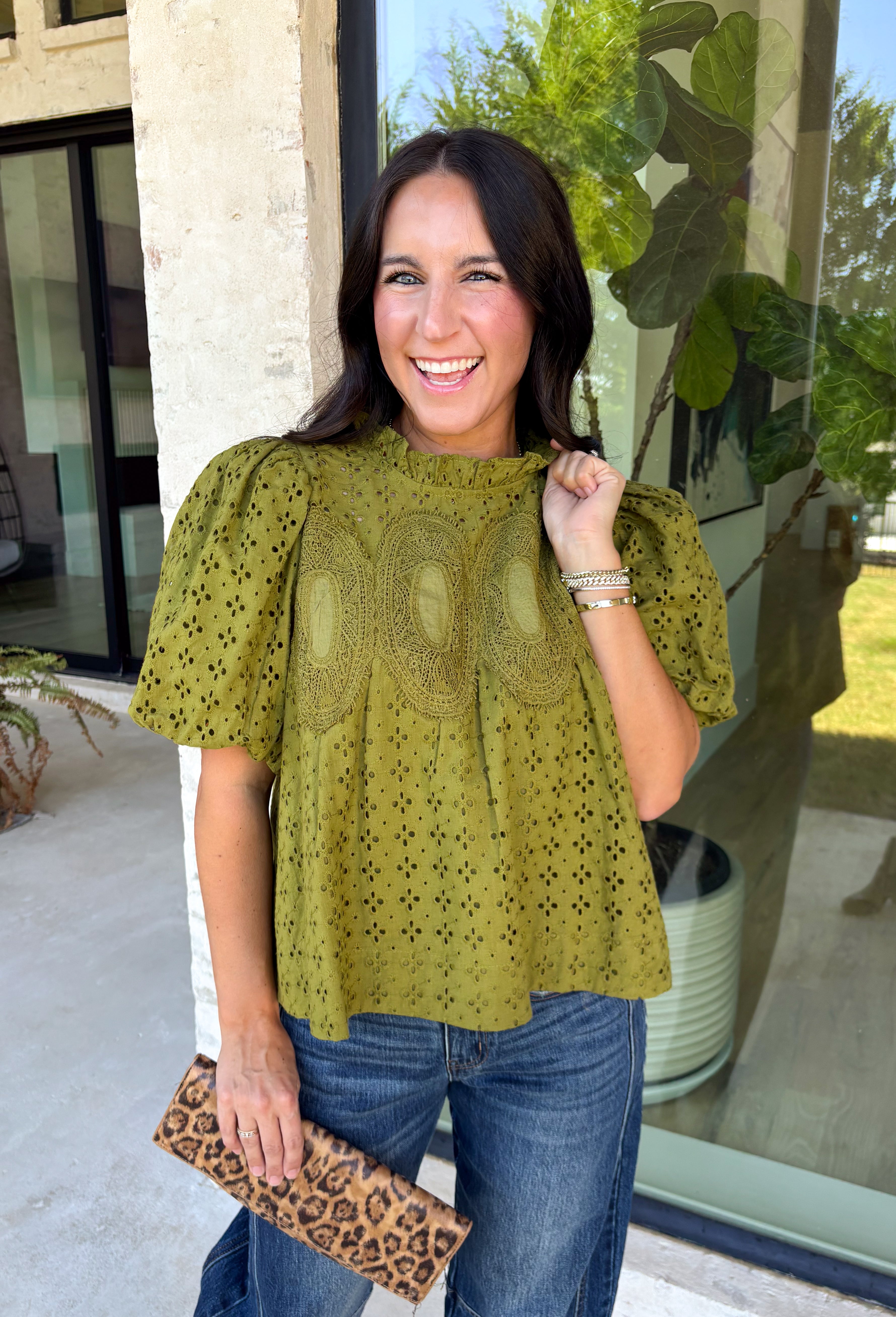 Pretty details make this olive top from Entro one you'll want to work into your fall rotation. The rich olive shade feels perfect for the season, while eyelet detailing and crochet trim add texture and interest to the solid design. A ruffled neckline brings a sweet finishing touch, and short puff sleeves give the silhouette just the right amount of shape. 