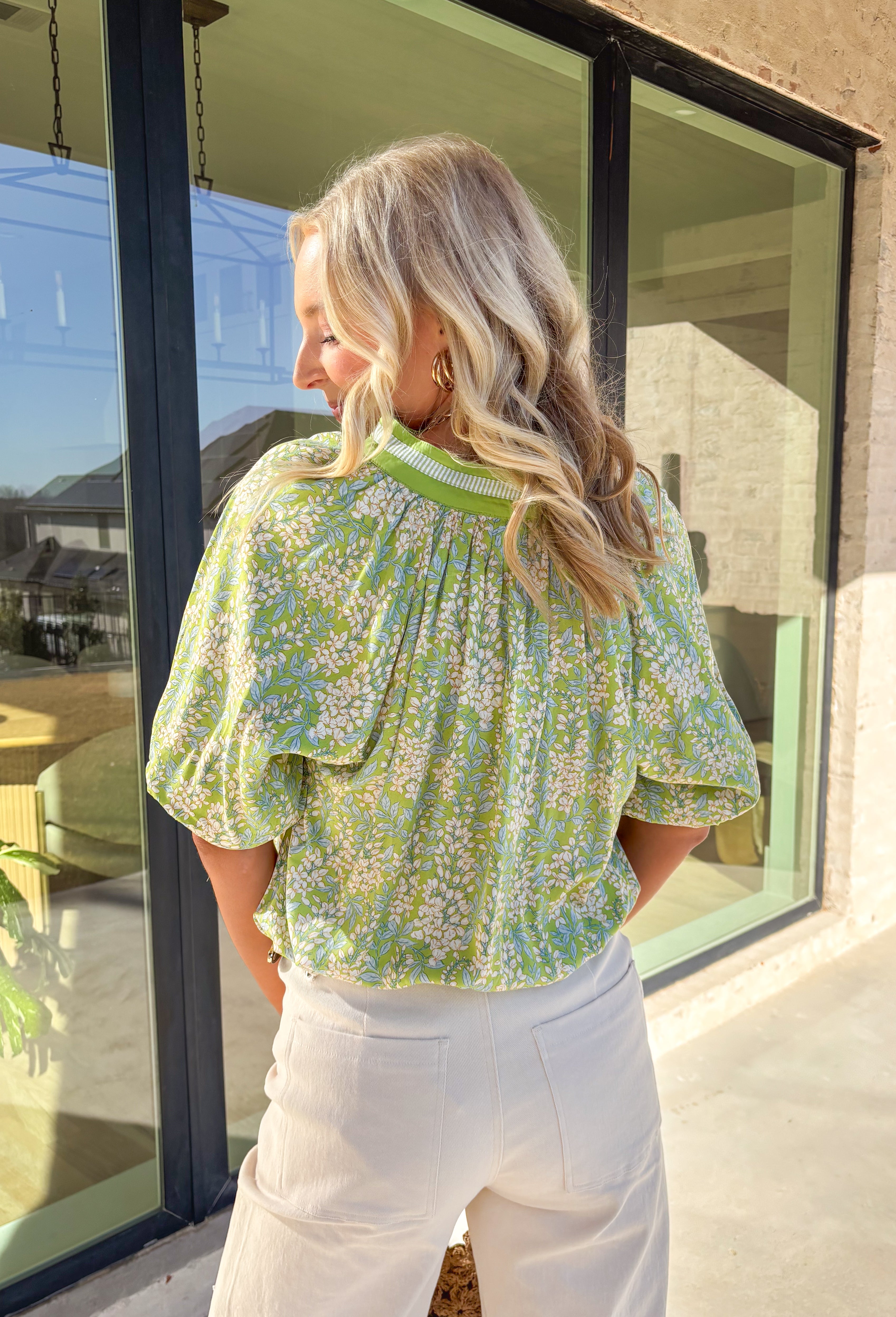 Easy, breezy, and perfect for spring days, this green short sleeve top by Umgee is full of soft charm. Featuring a neutral floral print with subtle pops of light blue, it keeps things light and wearable while still feeling special. The striped band detail along the front and sleeve cuffs adds a fun contrast, and the elastic ruffle cuffs give it a feminine finish that’s comfy and flattering for everyday wear.