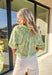 Easy, breezy, and perfect for spring days, this green short sleeve top by Umgee is full of soft charm. Featuring a neutral floral print with subtle pops of light blue, it keeps things light and wearable while still feeling special. The striped band detail along the front and sleeve cuffs adds a fun contrast, and the elastic ruffle cuffs give it a feminine finish that’s comfy and flattering for everyday wear.