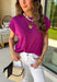 Add a beautiful pop of color to your fall wardrobe with this soft orchid knit top. The rich orchid hue brings a fresh twist to classic autumn styling, making it easy to pair with your favorite dark wash denim, cream trousers, or printed skirts. Designed with a timeless round neckline and flattering cap sleeves, this lightweight knit is perfect for layering under jackets and cardigans as the weather cools. 