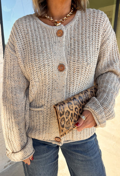 Wrap yourself in all the cozy fall vibes with this chunky knit cardigan! The neutral knit is beautifully accented with subtle orange and black speckles, giving it the perfect autumn-inspired look that's easy to style with everything in your closet. Finished with charming wooden buttons and functional front pockets, this cardigan is made for crisp mornings, pumpkin patch outings, coffee runs, and relaxing weekends. 