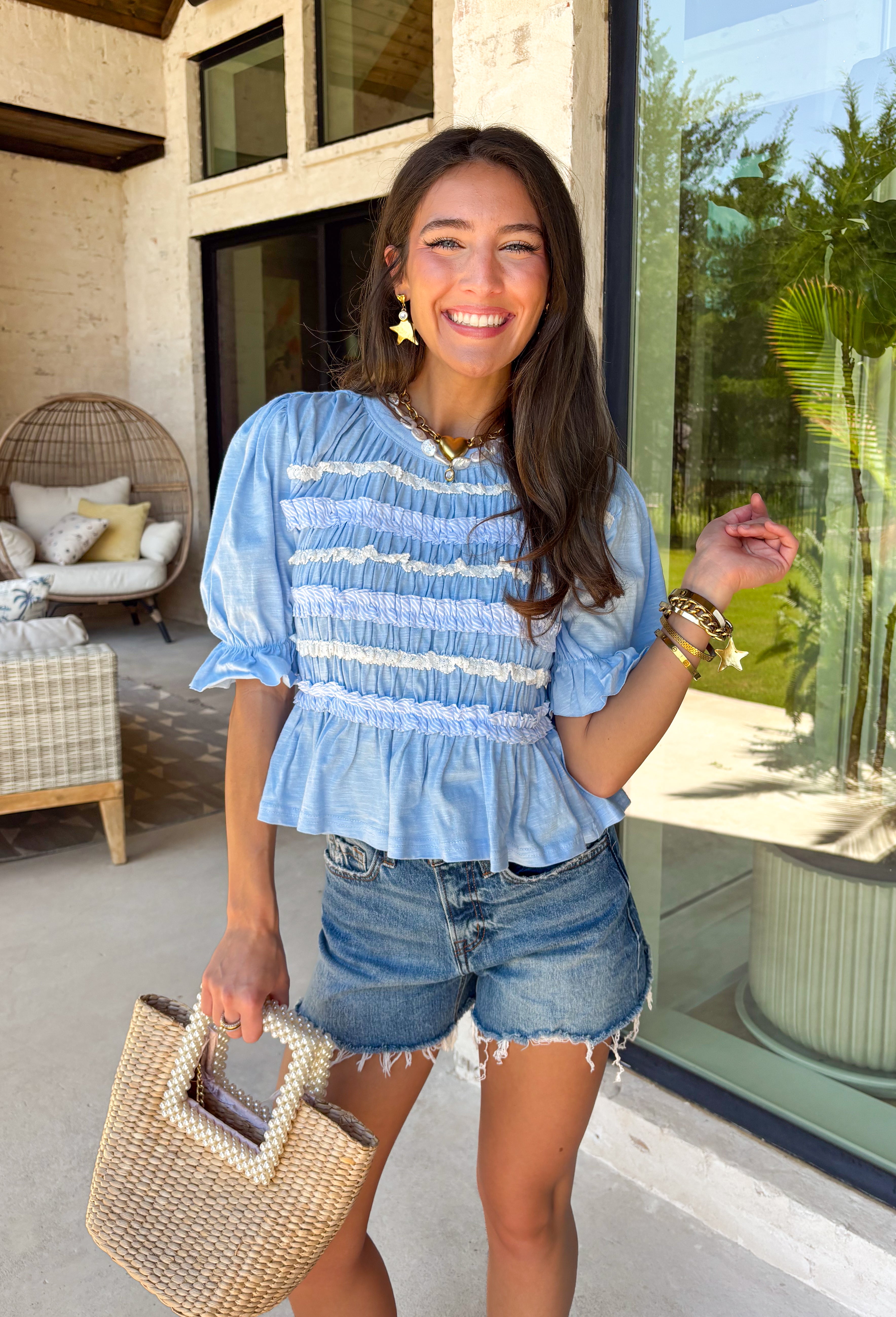 This blue lace ruffle top is such a dreamy piece for summer! With its delicate lace, layered ruffle details, and soft textured fabric, it brings the perfect mix of feminine and effortless style. The smocking throughout creates a flattering, comfortable fit while adding beautiful dimension. Lightweight and breathable in 100% cotton, it’s ideal for warm days when you still want something a little elevated. 