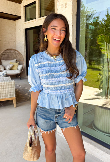 This blue lace ruffle top is such a dreamy piece for summer! With its delicate lace, layered ruffle details, and soft textured fabric, it brings the perfect mix of feminine and effortless style. The smocking throughout creates a flattering, comfortable fit while adding beautiful dimension. Lightweight and breathable in 100% cotton, it’s ideal for warm days when you still want something a little elevated. 