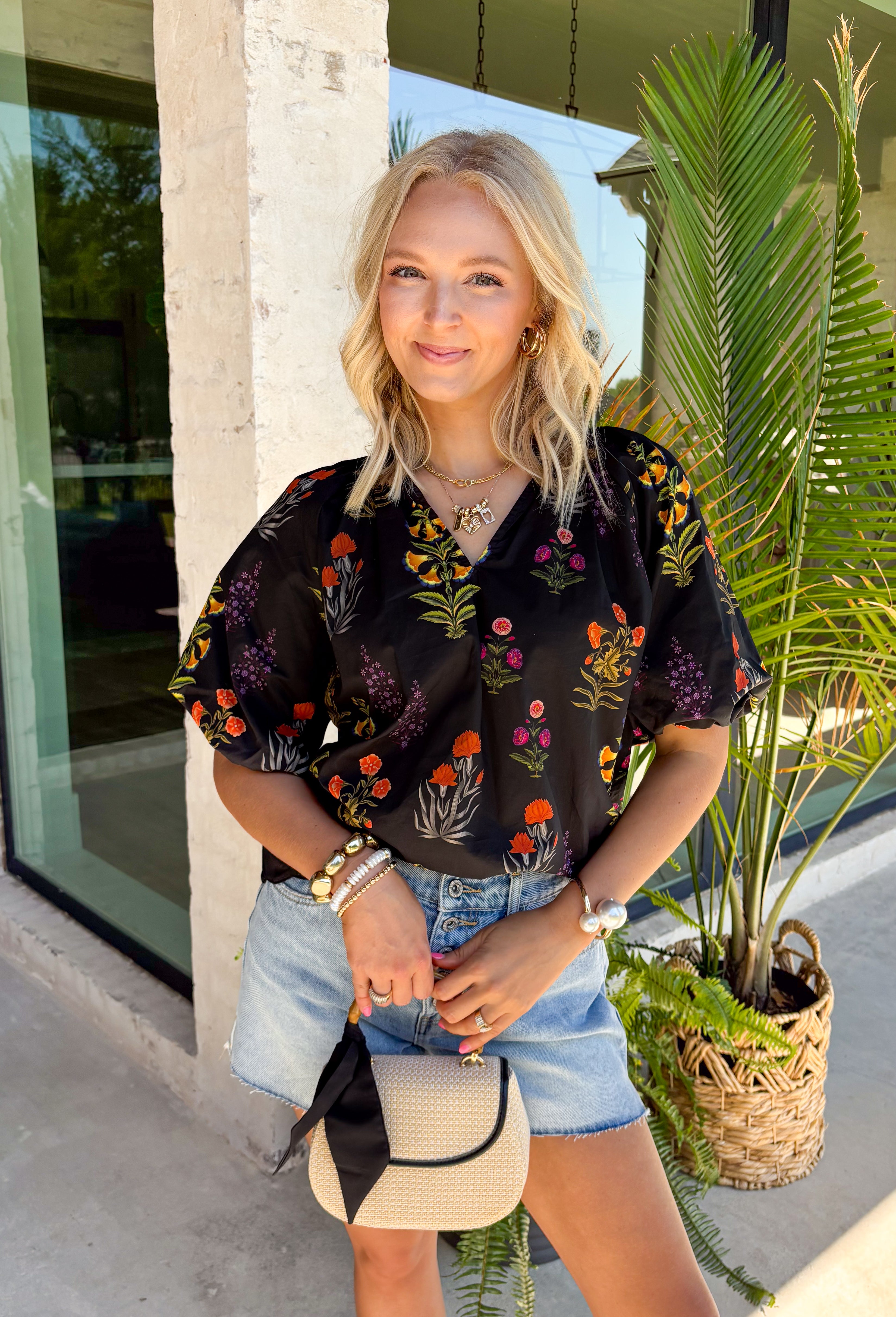 This black floral top is such a fun, vibrant pick for summer! The colorful mix of yellow, orange, purple, and green pops beautifully against the black base, making it an easy statement piece. The scalloped neckline and hem add the sweetest feminine detail, while the puff sleeves with elastic give it that flattering, easy shape. Lightweight and breathable in 100% cotton, it’s perfect for warm days when you still want to feel put together. 