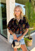 This black floral top is such a fun, vibrant pick for summer! The colorful mix of yellow, orange, purple, and green pops beautifully against the black base, making it an easy statement piece. The scalloped neckline and hem add the sweetest feminine detail, while the puff sleeves with elastic give it that flattering, easy shape. Lightweight and breathable in 100% cotton, it’s perfect for warm days when you still want to feel put together. 