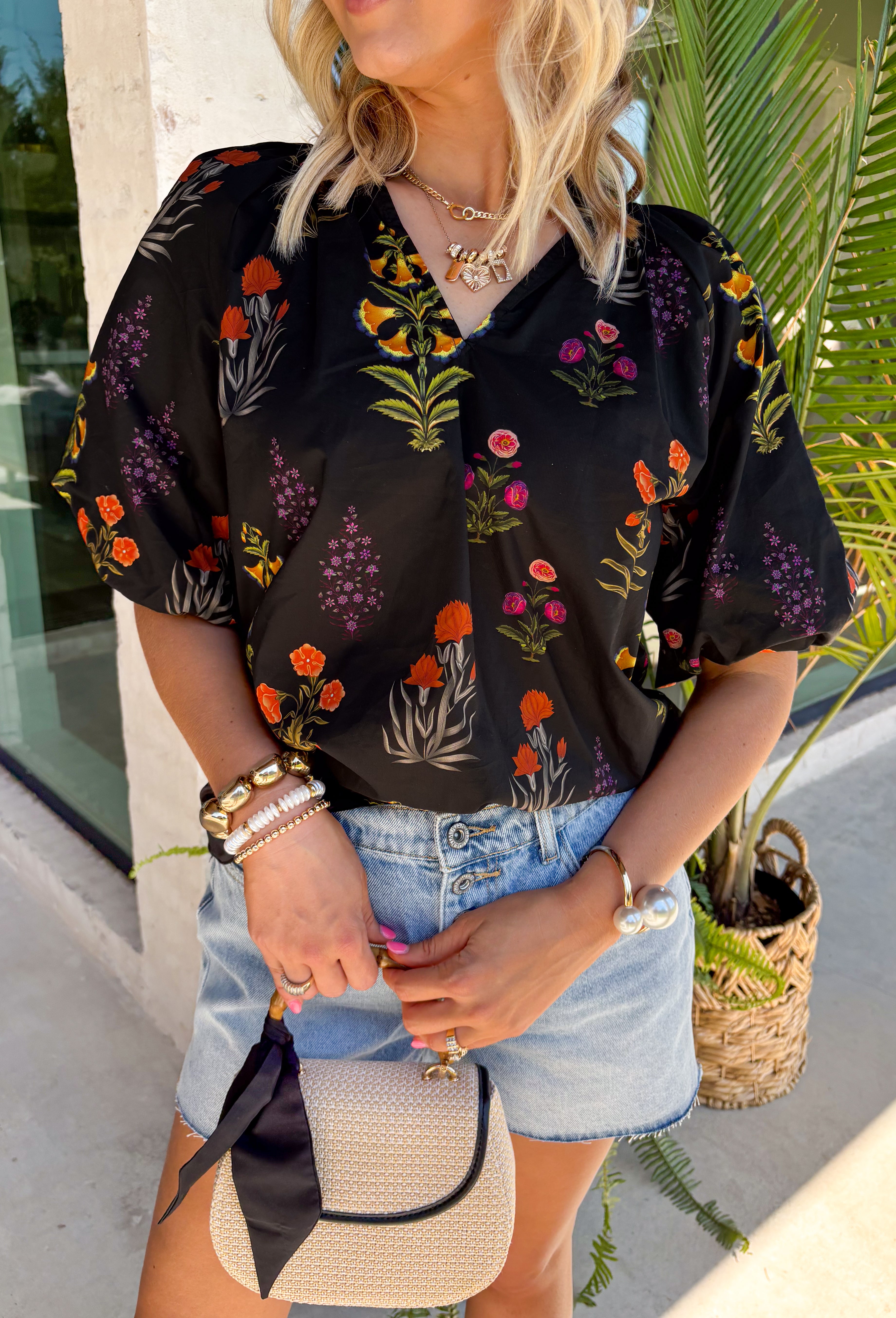 This black floral top is such a fun, vibrant pick for summer! The colorful mix of yellow, orange, purple, and green pops beautifully against the black base, making it an easy statement piece. The scalloped neckline and hem add the sweetest feminine detail, while the puff sleeves with elastic give it that flattering, easy shape. Lightweight and breathable in 100% cotton, it’s perfect for warm days when you still want to feel put together. 