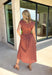 Capture the beauty of the season in this effortlessly charming rust midi dress. Featuring an abstract dainty floral and geo-inspired print with subtle pops of green, blue, and tan, this dress brings the perfect touch of autumn color to your wardrobe. The elastic waist with a self-tie detail creates a flattering, comfortable fit, while the button front and flowing midi silhouette give it timeless appeal. 
