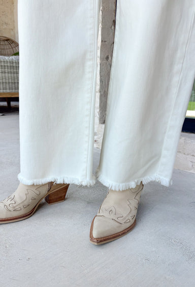 Meet the jeans you'll style with everything this season! These cream tummy control wide leg jeans are the perfect combination of flattering fit and everyday comfort. Designed with Risen's signature tummy control panel, they offer a smooth, supportive silhouette while maintaining all-day comfort. Crafted from clean, classic cream denim with warm tan stitching throughout, they're finished with a modern wide leg and raw hem for a timeless look you'll wear on repeat. 
