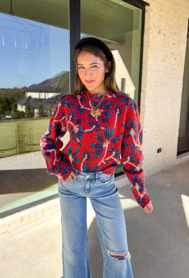 Make a statement this season in this red cropped sweater featuring an eye-catching abstract blue floral print. The cozy knit keeps you warm while the mock neck adds a touch of chic structure. With its cropped length, this sweater pairs effortlessly with high-rise jeans, skirts, or trousers—perfect for when you want comfort without sacrificing style.