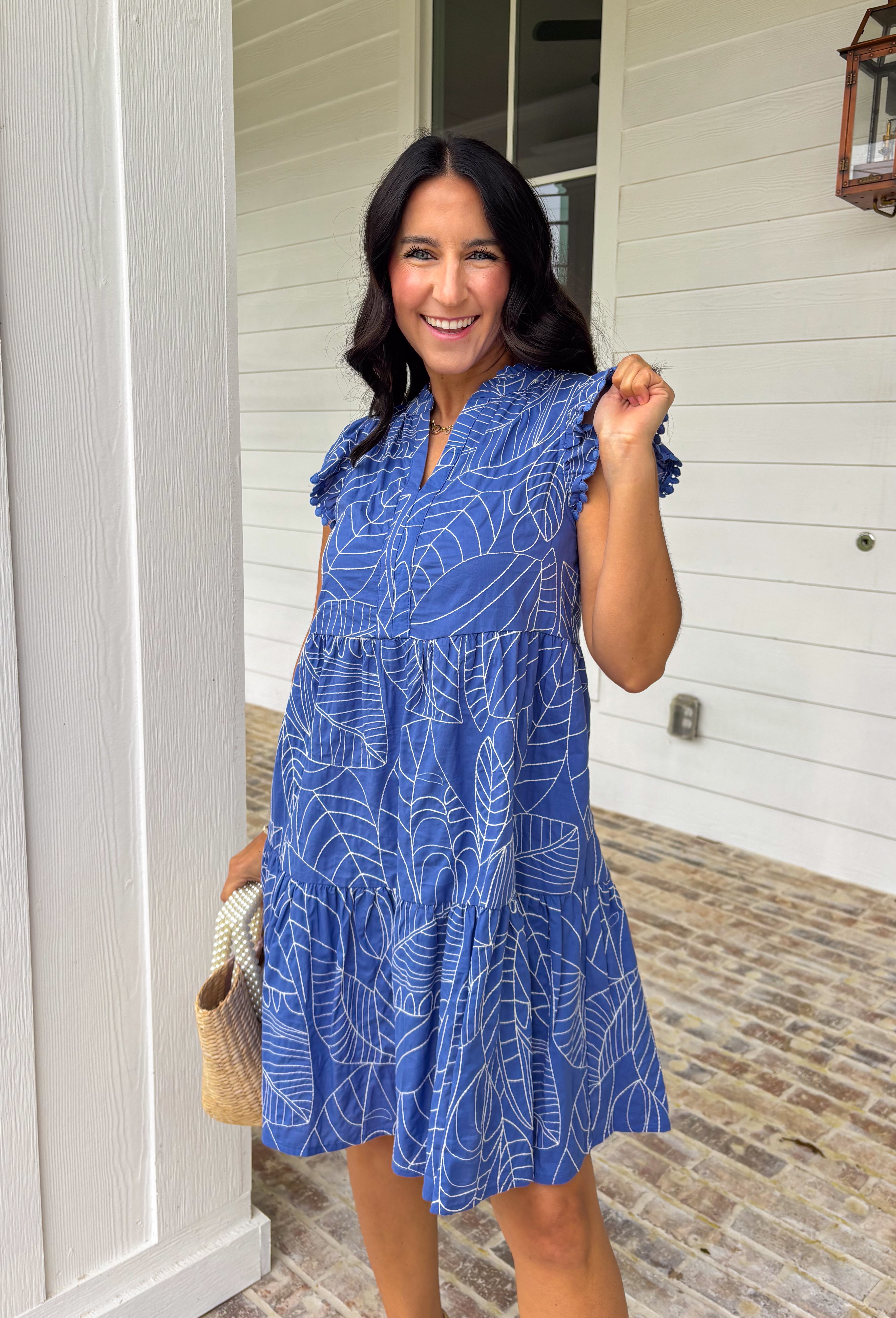 Easy, breezy, and full of tropical charm! This blue short sleeve tiered dress features a beautiful white embroidered leaf print that gives it that fresh, getaway-ready feel. The flowy tiered silhouette adds movement and comfort, making it perfect for warm spring days. Finished with embroidered trim on the sleeves for an extra touch of detail, this dress blends relaxed style with a polished look. 