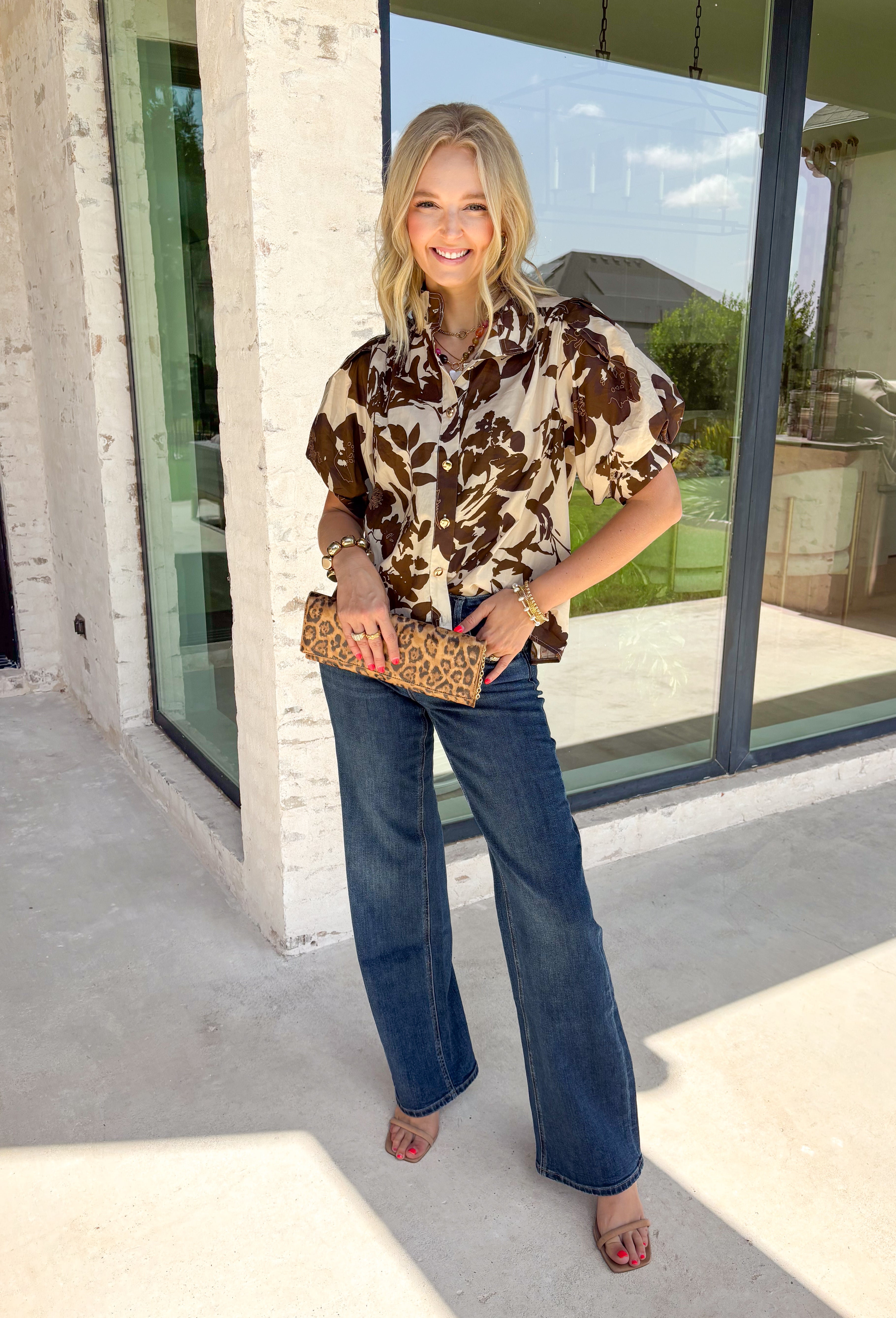Classic florals and elevated details make this blouse a beautiful addition to your fall wardrobe. Designed with a cream backdrop and a rich brown floral print, this timeless top offers an effortlessly polished look that's perfect for both work and weekends. The stand neckline creates a refined silhouette, while the gleaming gold button-front closure adds an elegant finishing touch. 