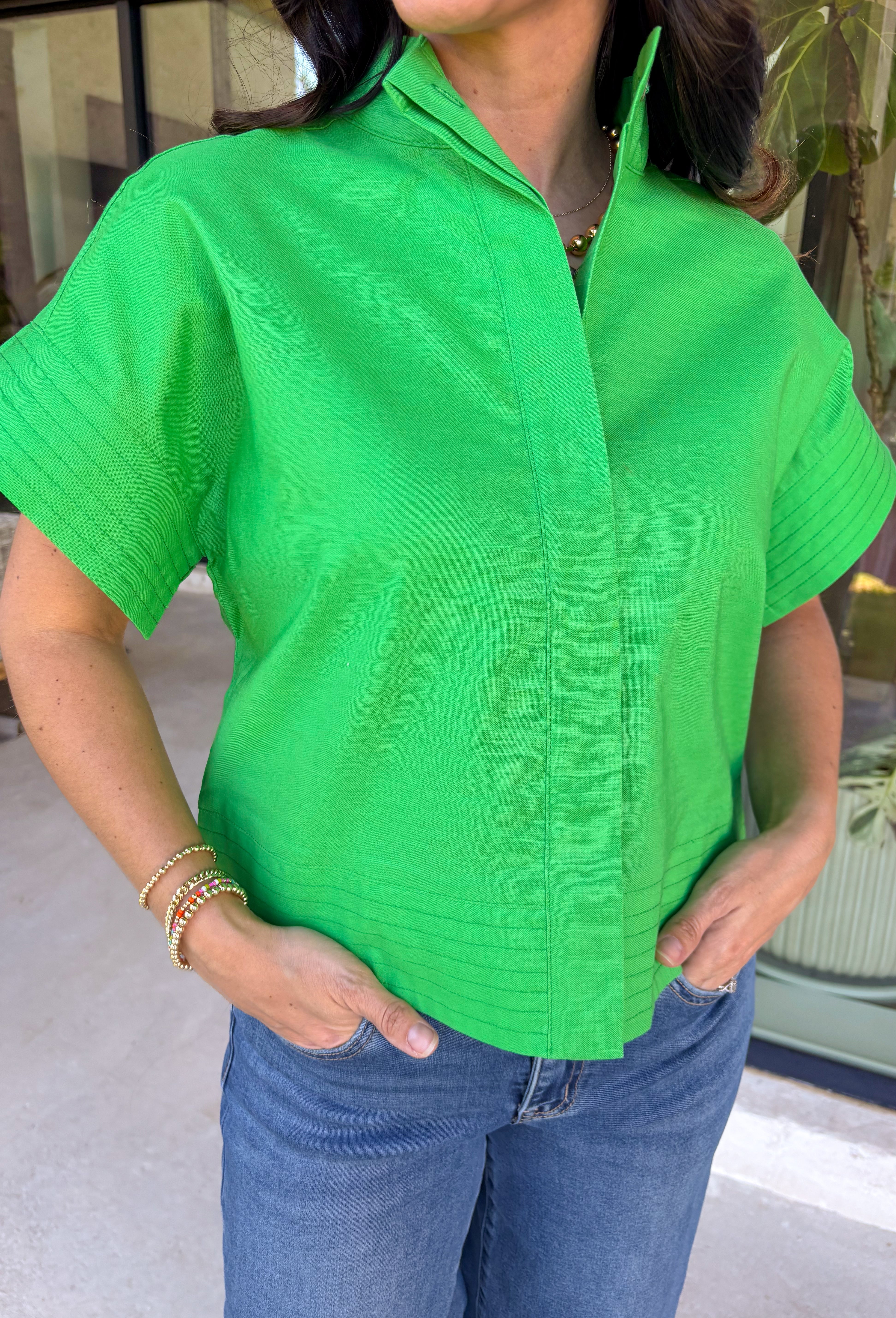 This kelly green short sleeve shirt is the kind of spring staple that instantly brightens up your whole outfit. The crisp color feels fresh and fun, while the hidden button down design keeps the look clean, polished, and effortlessly put-together. Made from a breathable cotton-linen blend, it’s lightweight enough for warmer days but still structured enough to wear to work, brunch, or wherever your calendar takes you. Just add denim and you’re good to go!