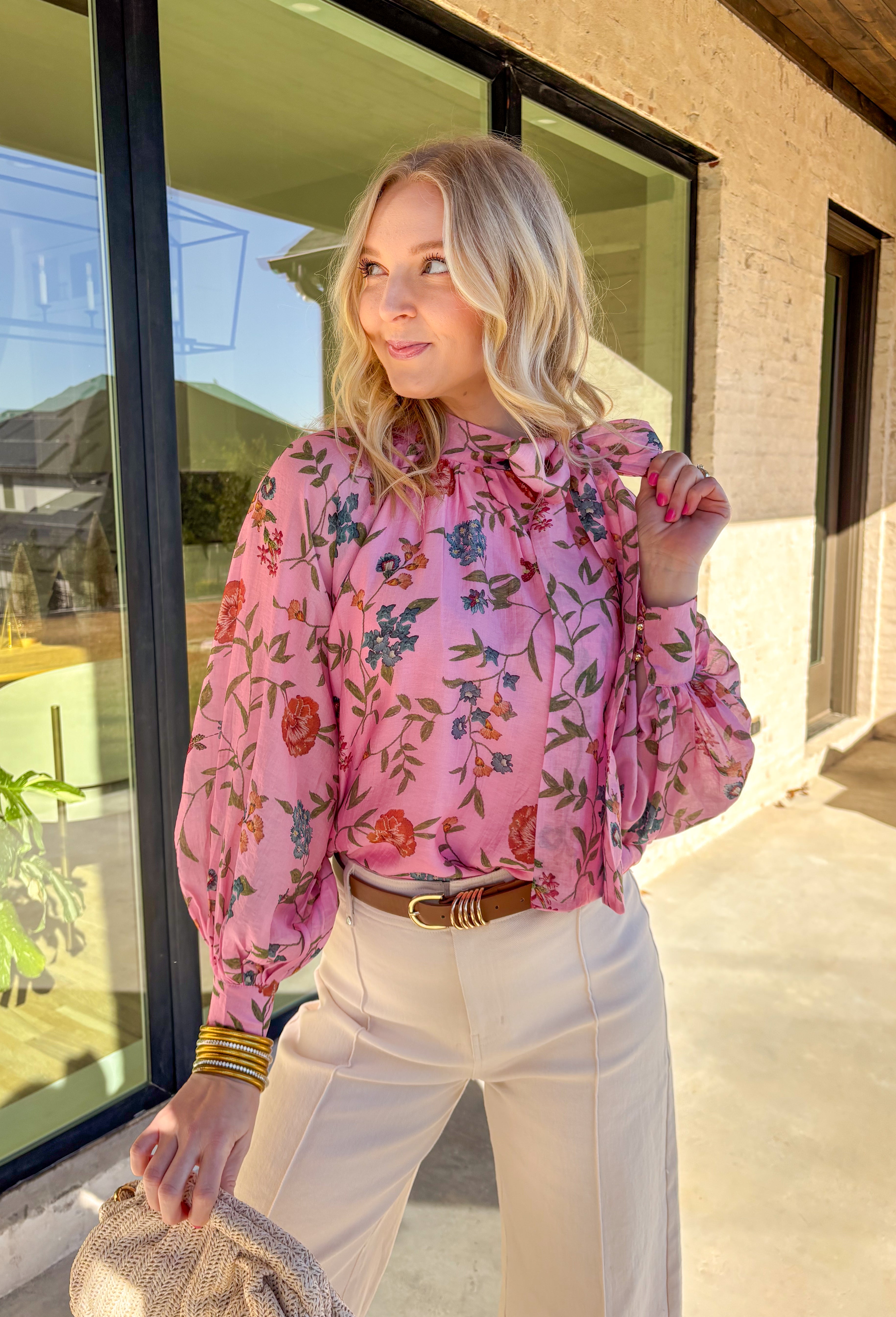 Soft, flowy, and full of spring charm, this pink long sleeve top by Entro is an effortless standout. Featuring a beautiful floral print with pops of green, blue, and brick, it brings the perfect mix of color while still feeling easy to wear. The matching self-tie neckline adds a sweet, elevated touch, and the balloon sleeves give it a romantic silhouette that feels light and breezy. Made from a silky tencel blend, this top drapes beautifully and feels amazing on.
