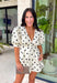 Classic polka dots and effortless style come together in this adorable two-piece set from Mable. Featuring an off-white and black polka dot print, this coordinating outfit is as versatile as it is charming. The short sleeve top is designed with feminine puff sleeves, a single button closure at the front, and a sweet tie detail at the back for an elevated finish. The matching shorts feature a comfortable elastic waistband, side zipper closure, and functional side pockets.