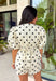 Classic polka dots and effortless style come together in this adorable two-piece set from Mable. Featuring an off-white and black polka dot print, this coordinating outfit is as versatile as it is charming. The short sleeve top is designed with feminine puff sleeves, a single button closure at the front, and a sweet tie detail at the back for an elevated finish. The matching shorts feature a comfortable elastic waistband, side zipper closure, and functional side pockets.