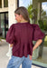 Elevate your everyday wardrobe with this beautifully detailed top from Entro. Designed in a rich merlot hue, this timeless blouse features elegant pleating throughout for added texture and a polished finish. Decorative front button details add classic charm, while the puff sleeves create a feminine silhouette that's easy to dress up or down. Crafted from a lightweight fabric blend, this versatile top is perfect for everything from workdays to weekend brunches and seasonal gatherings.