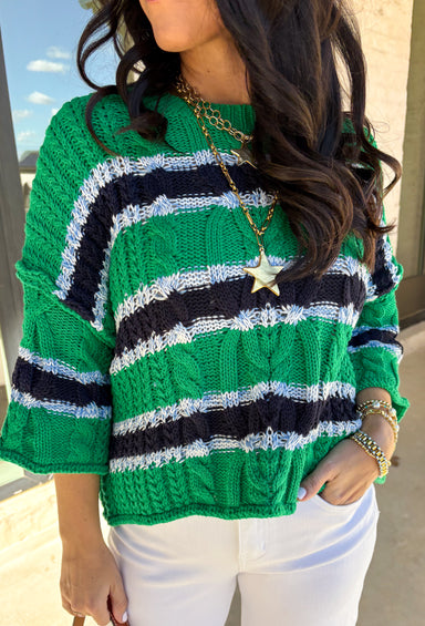 Classic with a fresh spring twist, this striped knit sweater by Entro is an easy piece to reach for on cooler spring days. Featuring a round neckline and ¾ length sleeves, it’s finished with subtle cable knit detailing that adds texture without feeling heavy. The green base is accented with black, blue, and white stripes, giving it a timeless look that pairs effortlessly with denim, trousers, or skirts.
