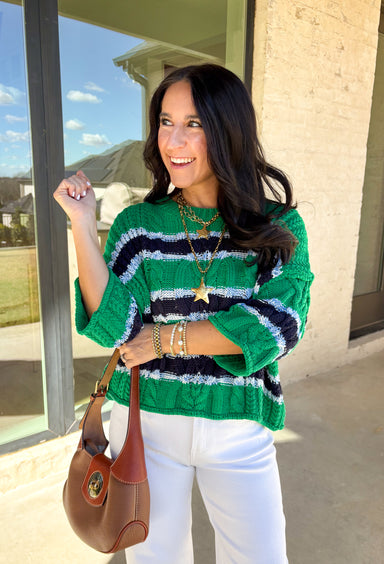 Classic with a fresh spring twist, this striped knit sweater by Entro is an easy piece to reach for on cooler spring days. Featuring a round neckline and ¾ length sleeves, it’s finished with subtle cable knit detailing that adds texture without feeling heavy. The green base is accented with black, blue, and white stripes, giving it a timeless look that pairs effortlessly with denim, trousers, or skirts.