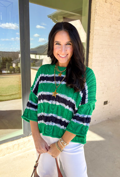 Classic with a fresh spring twist, this striped knit sweater by Entro is an easy piece to reach for on cooler spring days. Featuring a round neckline and ¾ length sleeves, it’s finished with subtle cable knit detailing that adds texture without feeling heavy. The green base is accented with black, blue, and white stripes, giving it a timeless look that pairs effortlessly with denim, trousers, or skirts.