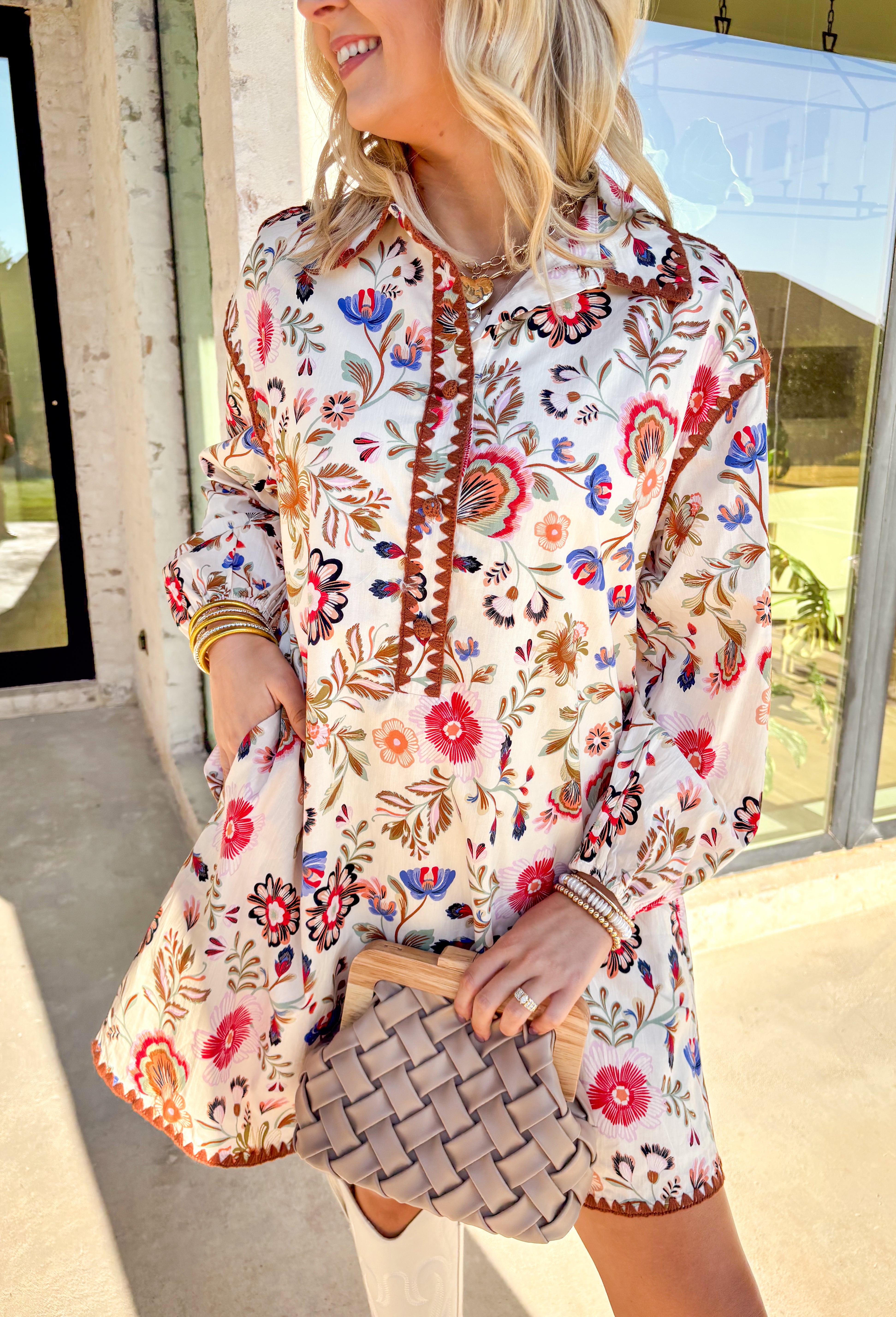 This cream long sleeve dress by &amp;Merci captures effortless boho charm with its colorful floral print and beautifully detailed embroidery. Rust-toned stitching accents the sleeves, collar, front, and hem, adding rich texture and depth to the design. The half button-down front and elastic sleeves keep it comfortable, while the fully lined cotton fabric makes it easy to wear from day to night. A standout piece that blends color, comfort, and fall-ready style.