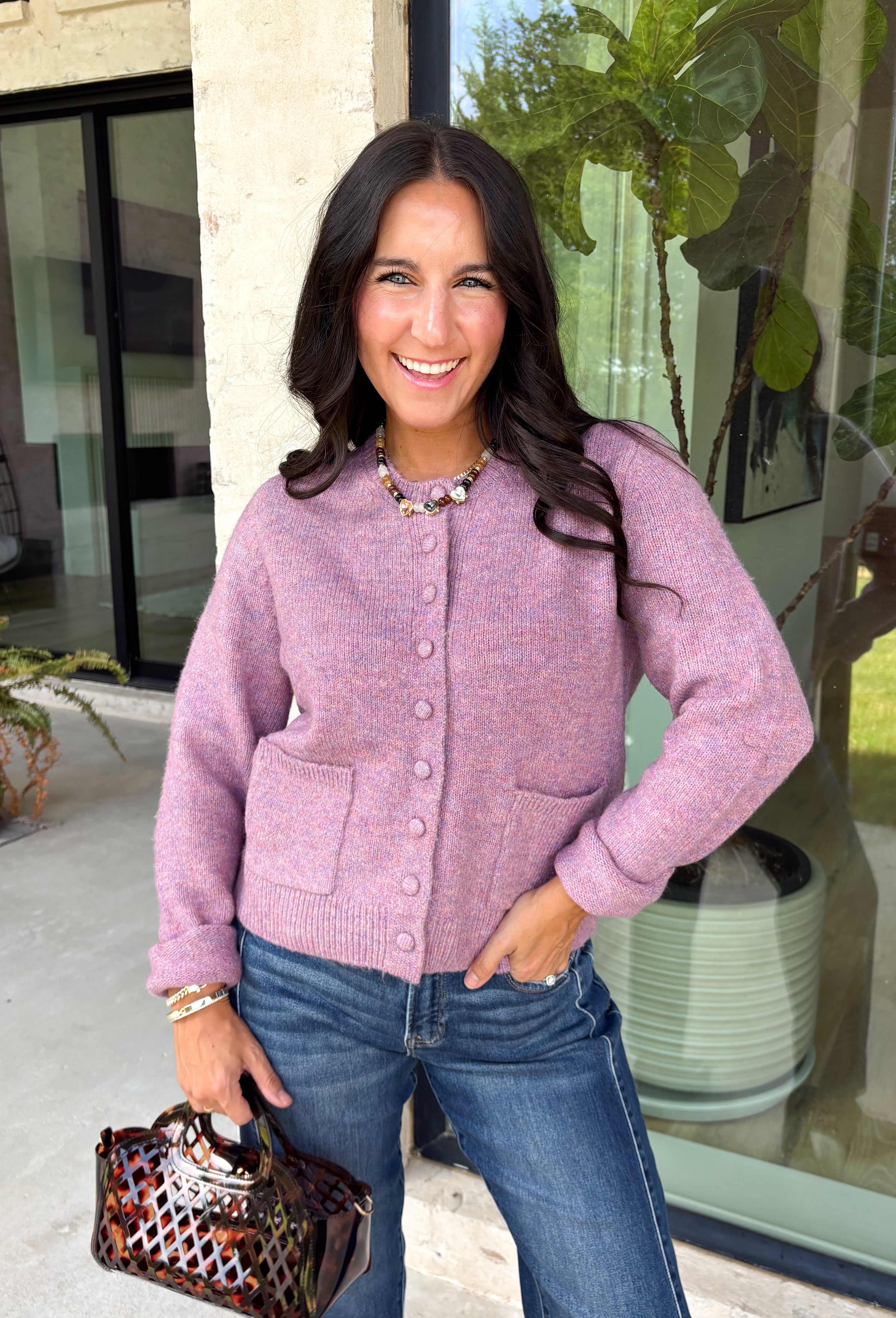 Wrap yourself in all the cozy vibes this season with this beautiful knit cardigan! Featuring gorgeous shades of purple woven throughout, this button-down cardigan is the perfect layering piece for crisp autumn mornings and cozy evenings. Front pockets add a practical touch, while the soft knit fabric makes it one you'll reach for again and again. Whether you're heading to brunch, the office, or enjoying a weekend at the pumpkin patch, this cardigan brings effortless comfort and style to every outfit.