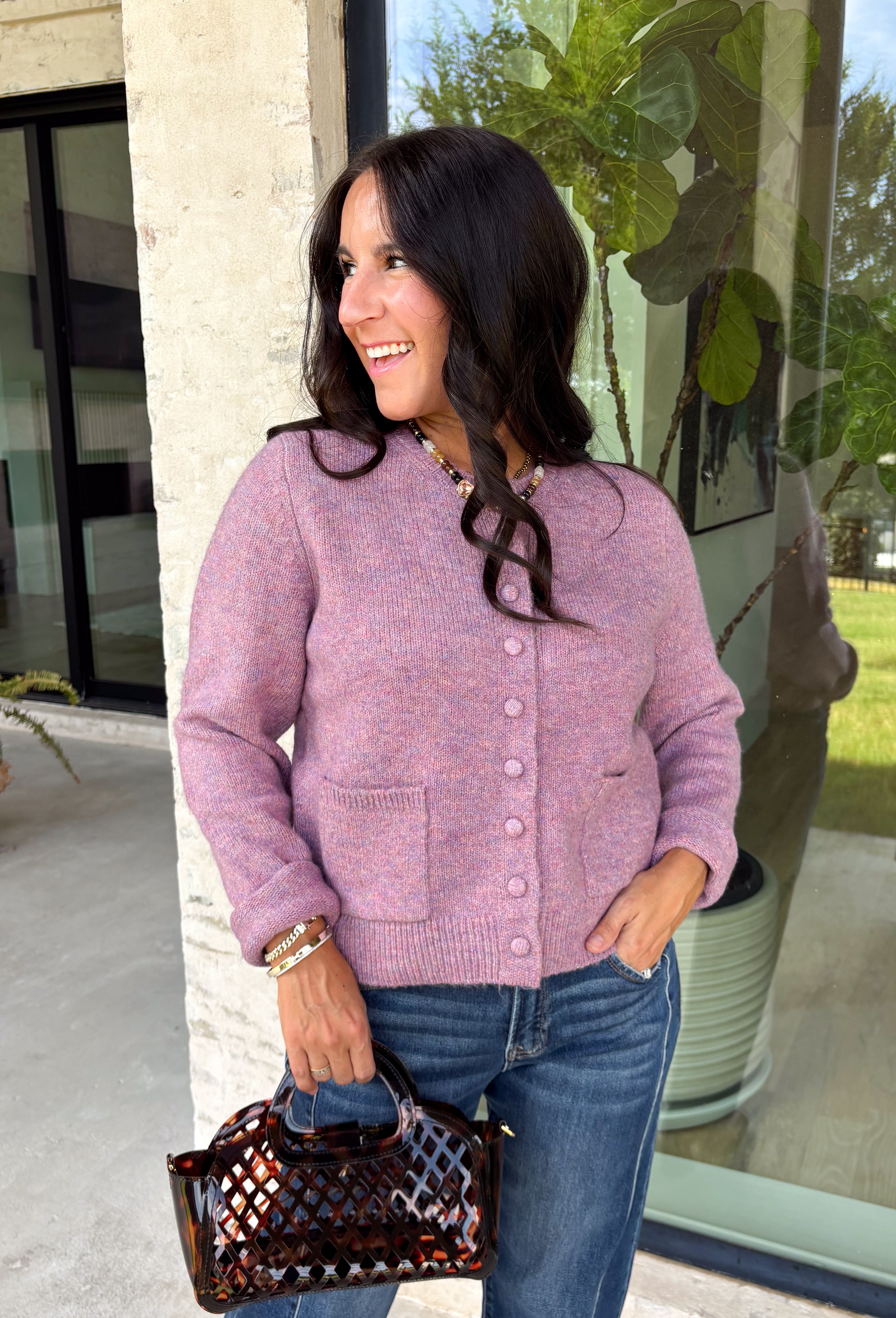 Wrap yourself in all the cozy vibes this season with this beautiful knit cardigan! Featuring gorgeous shades of purple woven throughout, this button-down cardigan is the perfect layering piece for crisp autumn mornings and cozy evenings. Front pockets add a practical touch, while the soft knit fabric makes it one you'll reach for again and again. Whether you're heading to brunch, the office, or enjoying a weekend at the pumpkin patch, this cardigan brings effortless comfort and style to every outfit.