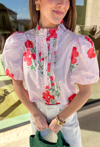 Sweet, fresh, and full of spring charm, this white and light pink striped top by Entro is as pretty as it gets. Featuring a light red floral print throughout with pops of green, it gives you the perfect mix of soft stripes and cheerful blooms. The front ruffle trim and button details add a darling touch, while puff sleeves create that feminine, slightly dressy silhouette we love for spring. Made from breathable cotton, it’s an easy top to wear for brunch, showers, or any day you want to feel extra cute.