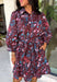 Celebrate the beauty of fall in this effortlessly chic dress from Entro. Designed with a rich brown backdrop and a beautiful floral and leaf print in autumn shades, this timeless dress is full of charming details. The classic shirt collar and button-front closure create a polished look, while the self-tie belt and elastic back waist provide a flattering, comfortable fit. Finished with ¾ balloon sleeves, a feminine tiered hem, convenient side pockets, and a fully lined design.