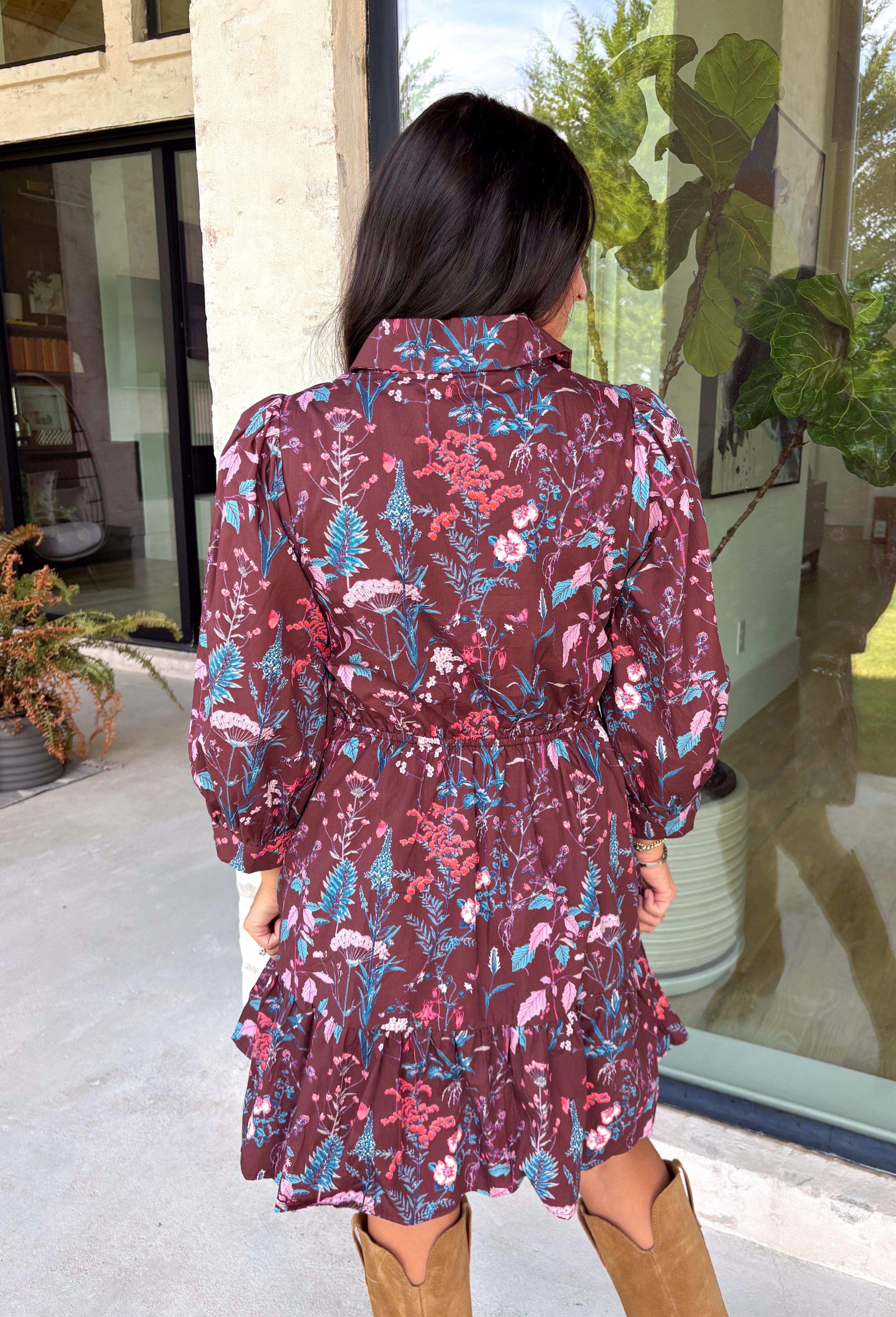 Celebrate the beauty of fall in this effortlessly chic dress from Entro. Designed with a rich brown backdrop and a beautiful floral and leaf print in autumn shades, this timeless dress is full of charming details. The classic shirt collar and button-front closure create a polished look, while the self-tie belt and elastic back waist provide a flattering, comfortable fit. Finished with ¾ balloon sleeves, a feminine tiered hem, convenient side pockets, and a fully lined design.