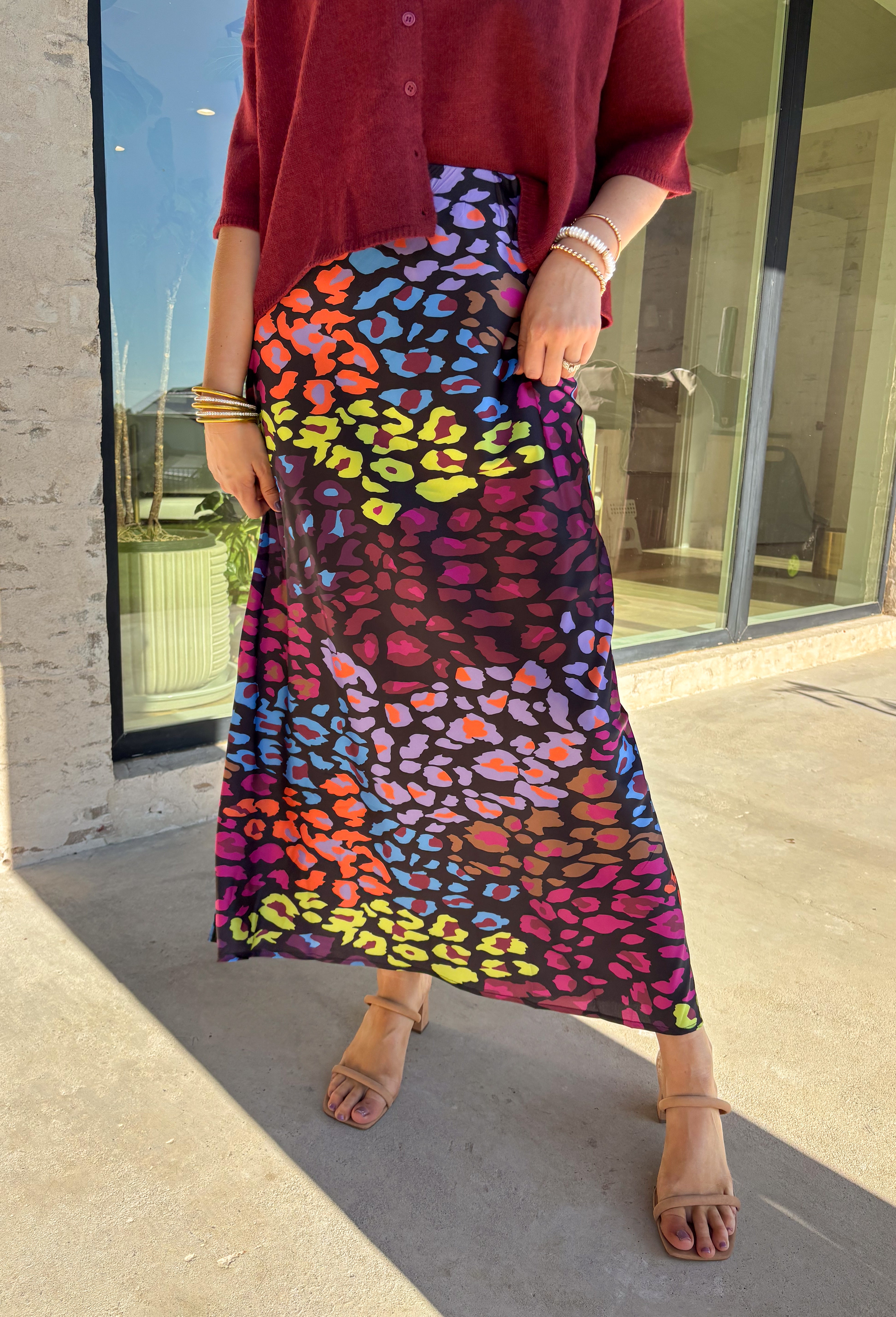 Bold and playful with a sleek twist, this satin maxi skirt is ready to steal the spotlight. The black background makes the vibrant leopard print—lime green, orange, pink, purple, and blue—pop beautifully, giving you a statement piece that still feels versatile. The elastic waistband keeps it comfortable and easy to wear, while the flowing maxi length adds a touch of drama. Perfect for dressing up with heels or styling casually with a tucked-in sweater and sneakers, this skirt brings a punch of personality t