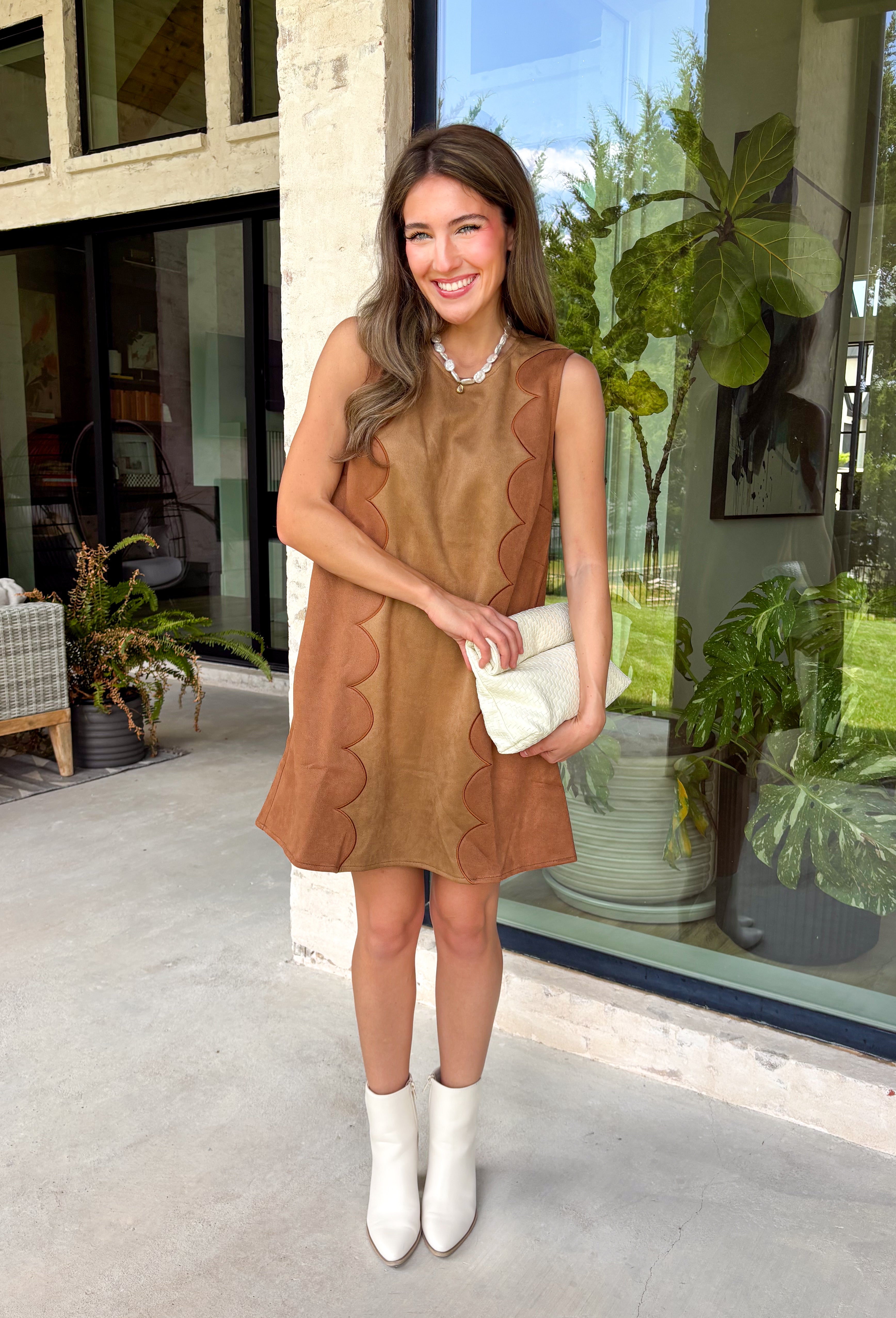 Elevate your fall wardrobe with this effortlessly chic dress from Day + Moon. Designed in a rich camel faux suede, this sleeveless silhouette features beautiful brown scalloped detailing that adds the perfect touch of feminine charm. The soft, stretchy fabric offers all-day comfort, while the back zipper closure creates a sleek, flattering fit. Whether you're headed to brunch, family photos, or a special seasonal event, this timeless dress is an easy choice for looking polished and put together.