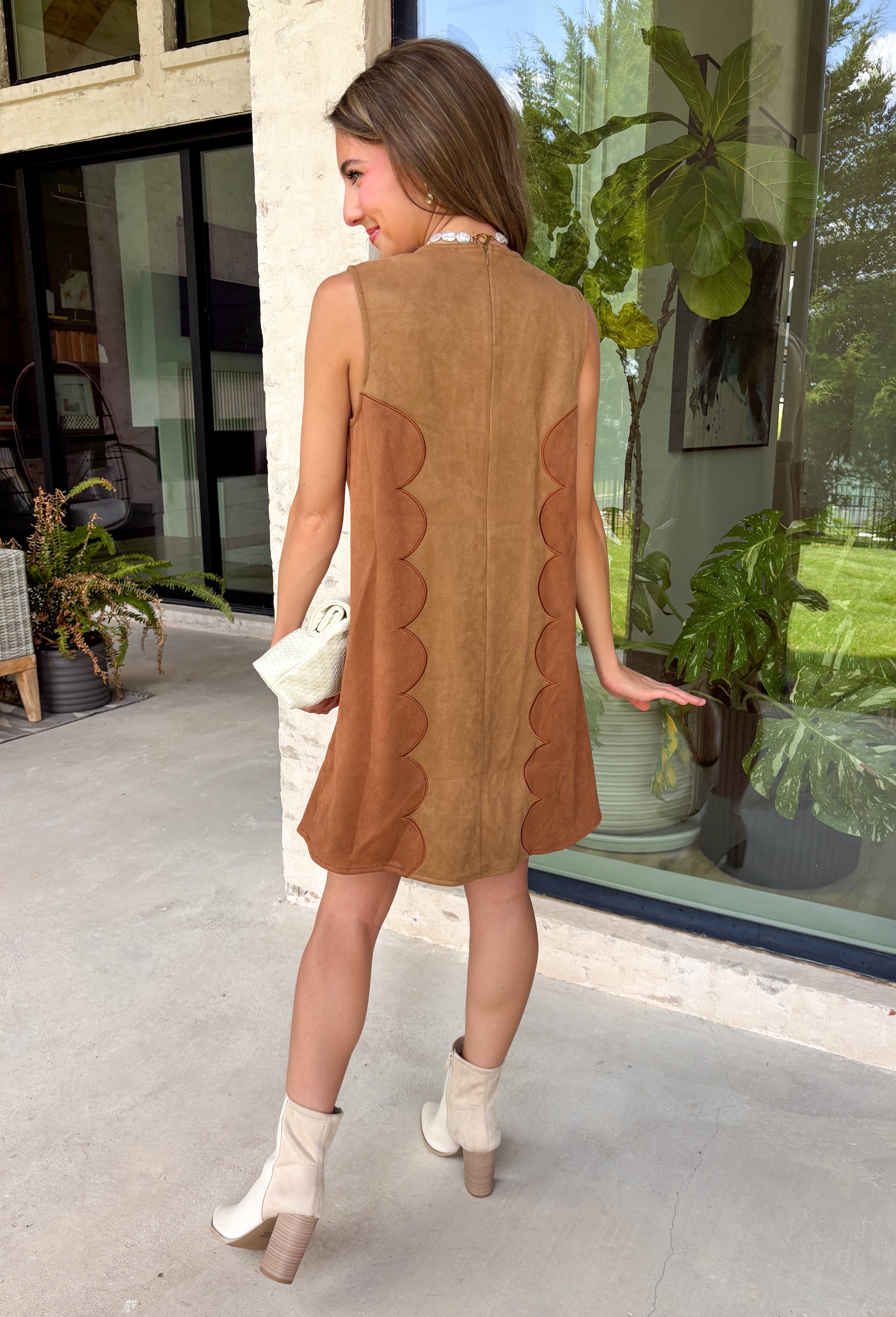 Elevate your fall wardrobe with this effortlessly chic dress from Day + Moon. Designed in a rich camel faux suede, this sleeveless silhouette features beautiful brown scalloped detailing that adds the perfect touch of feminine charm. The soft, stretchy fabric offers all-day comfort, while the back zipper closure creates a sleek, flattering fit. Whether you're headed to brunch, family photos, or a special seasonal event, this timeless dress is an easy choice for looking polished and put together.