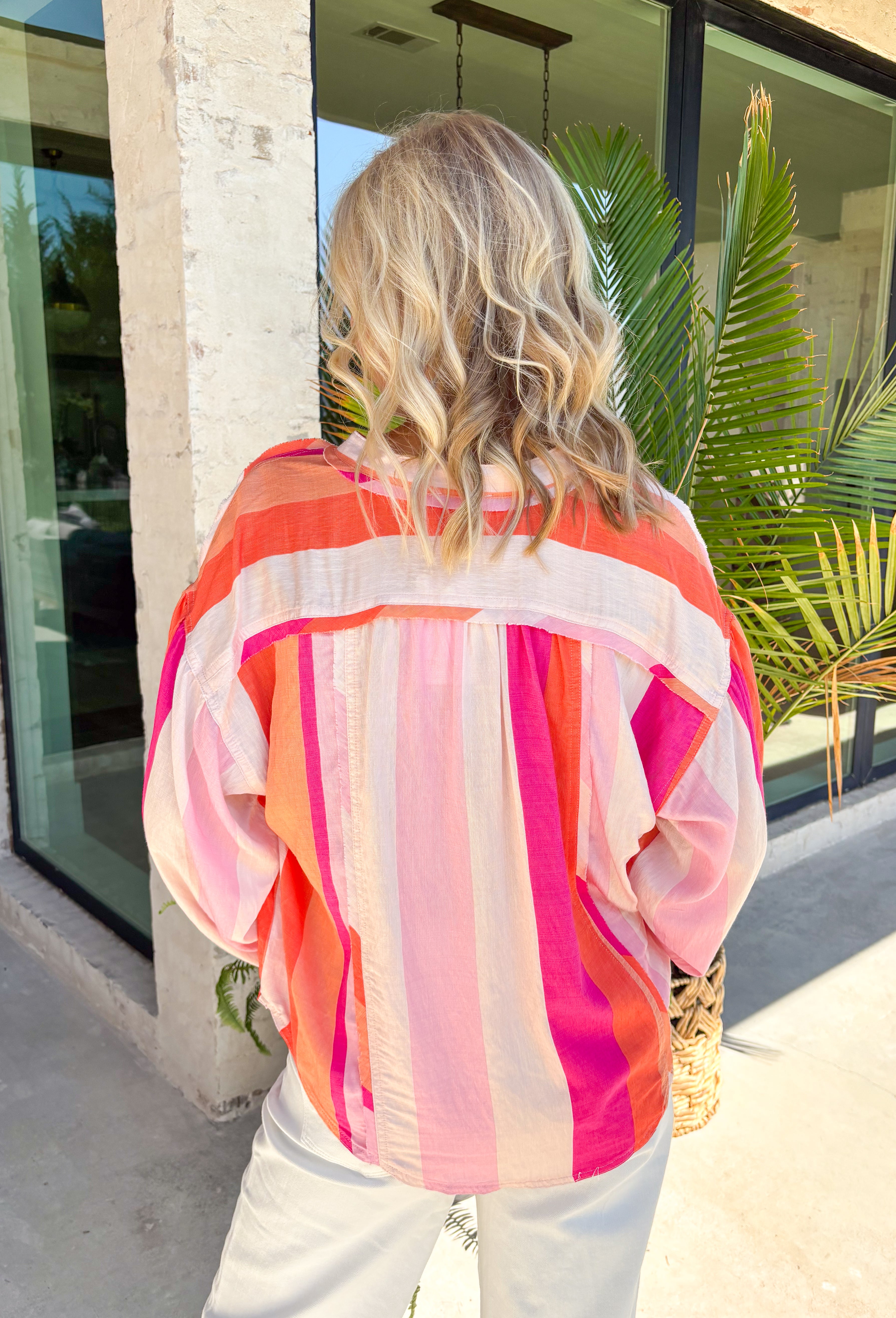 This colorful stripe button down top is bringing all the sunset-inspired summer vibes! With shades of pink and coral, it adds the prettiest pop of color while still feeling soft and easy to style. Lightweight and breathable, it’s perfect for layering over a tank or wearing on its own for an effortless, put-together look. The classic button down design keeps it timeless, while the vibrant stripes make it stand out. 