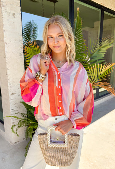 This colorful stripe button down top is bringing all the sunset-inspired summer vibes! With shades of pink and coral, it adds the prettiest pop of color while still feeling soft and easy to style. Lightweight and breathable, it’s perfect for layering over a tank or wearing on its own for an effortless, put-together look. The classic button down design keeps it timeless, while the vibrant stripes make it stand out. 