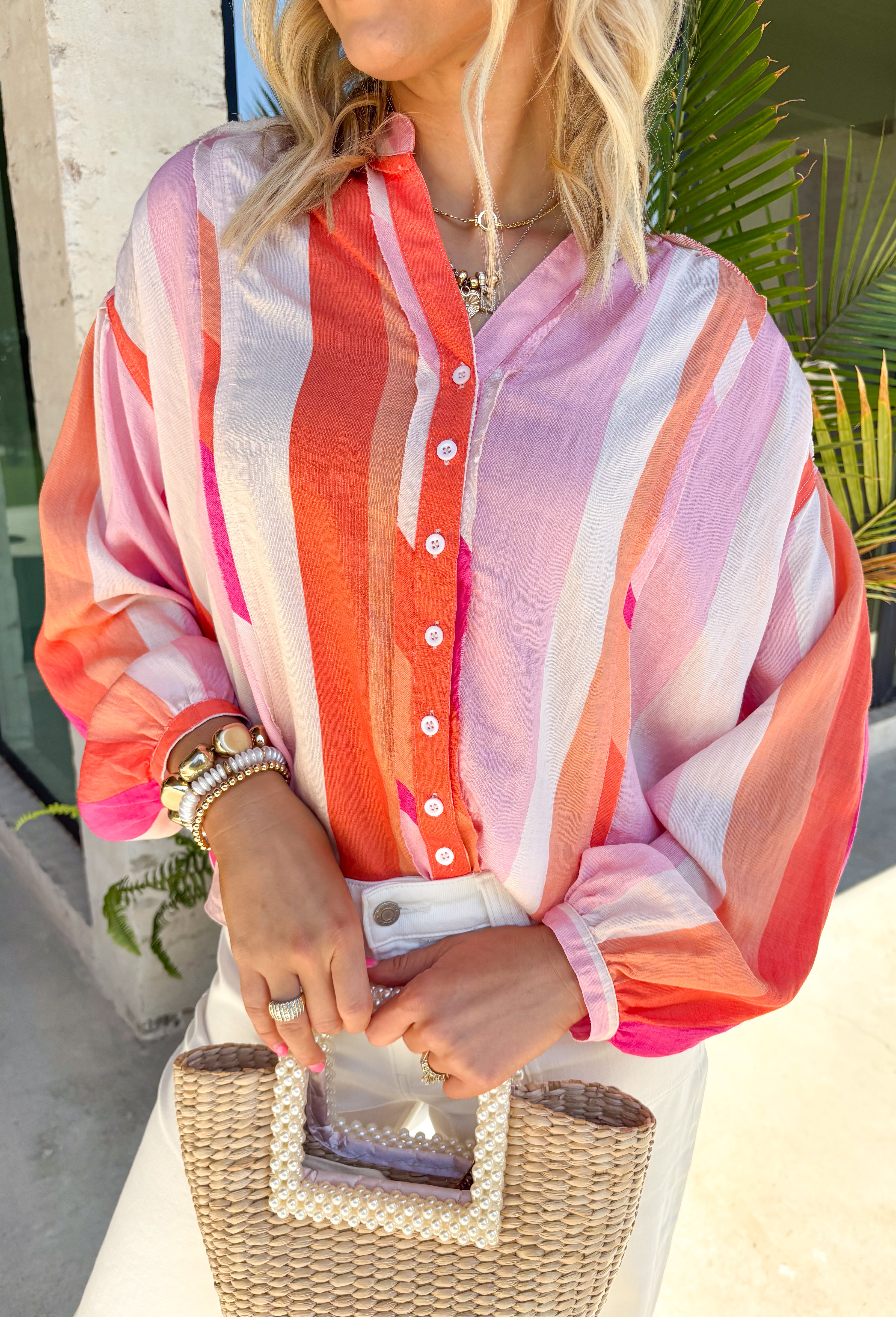 This colorful stripe button down top is bringing all the sunset-inspired summer vibes! With shades of pink and coral, it adds the prettiest pop of color while still feeling soft and easy to style. Lightweight and breathable, it’s perfect for layering over a tank or wearing on its own for an effortless, put-together look. The classic button down design keeps it timeless, while the vibrant stripes make it stand out. 