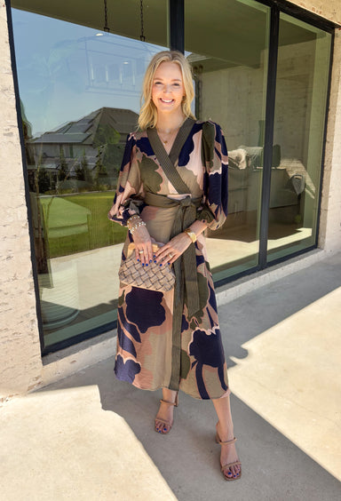 All the colors we love for fall come together in this printed midi dress from Entro. A mix of olive, navy, and tan creates a rich seasonal palette that feels right at home at autumn gatherings, family photos, and weekend plans. The v-neckline is accented with contrast stripe trim for a fun mix of prints, while long balloon sleeves add beautiful shape to the silhouette. A coordinating self-tie belt lets you define the waist, and convenient side pockets make it even easier to wear. 