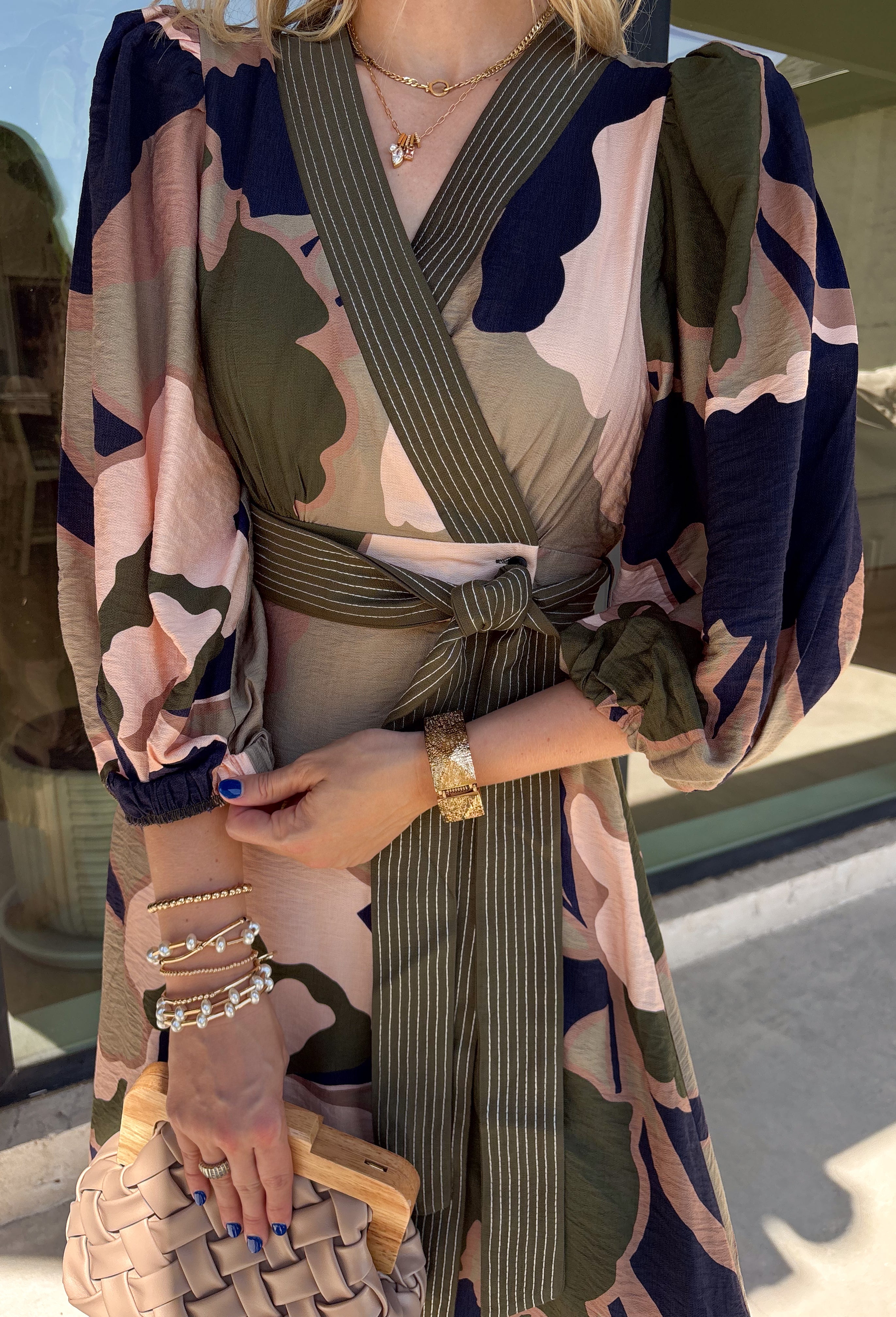 All the colors we love for fall come together in this printed midi dress from Entro. A mix of olive, navy, and tan creates a rich seasonal palette that feels right at home at autumn gatherings, family photos, and weekend plans. The v-neckline is accented with contrast stripe trim for a fun mix of prints, while long balloon sleeves add beautiful shape to the silhouette. A coordinating self-tie belt lets you define the waist, and convenient side pockets make it even easier to wear. 