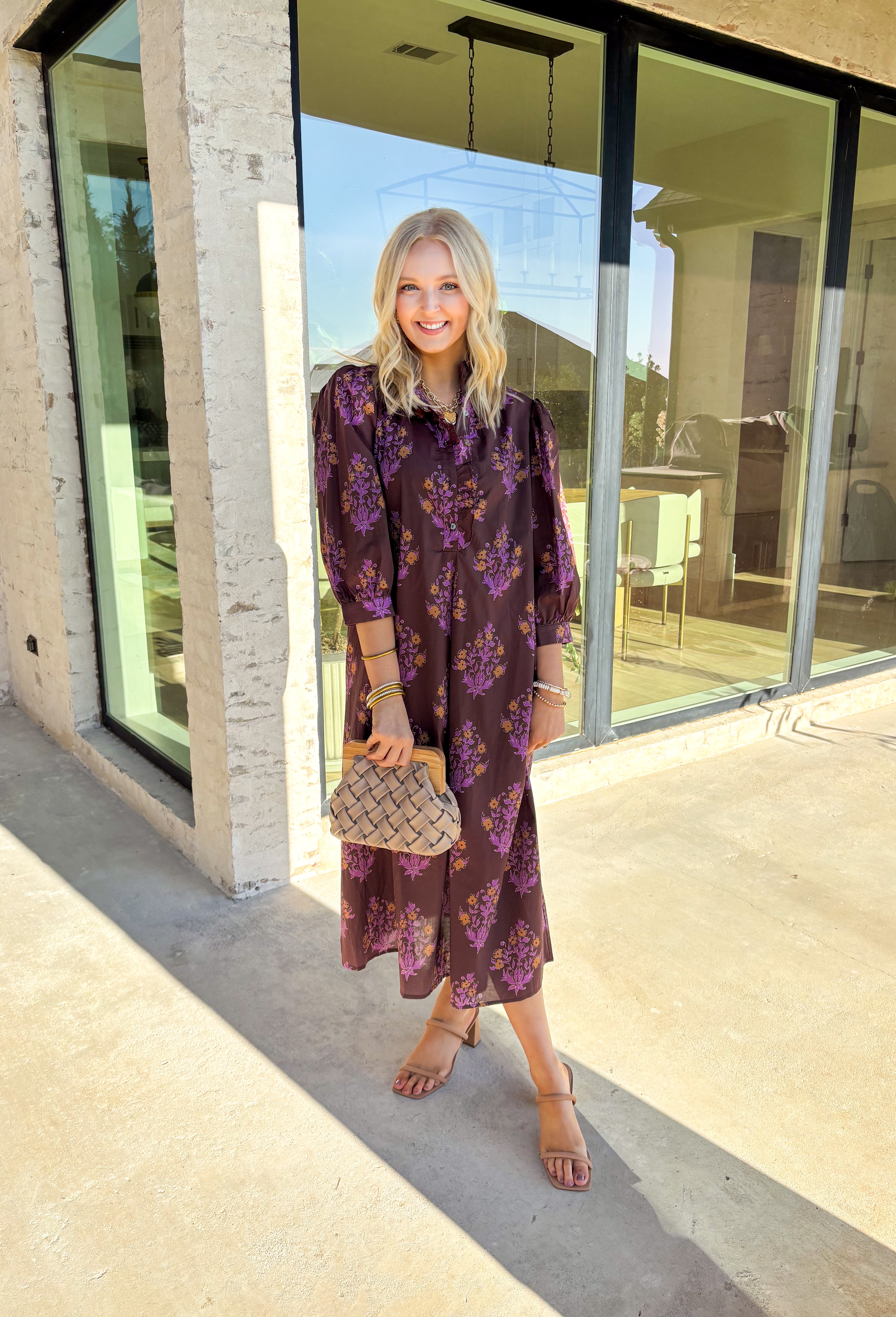 Earthy tones meet feminine charm in this beautiful botanical print midi dress by Entro. Designed with ¾ sleeves and a soft ruffle trim along the collar and front placket, it’s full of subtle details that make it feel special. The button-front design and side pockets bring functionality, while the brown base with purple and dark yellow florals gives it that perfect fall color palette. Fully lined and made from breathable cotton, it’s comfortable enough for all-day wear while keeping your look effortlessly po
