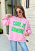 Add a little western attitude to your cozy season! This playful pink mock neck sweatshirt features a bold "Cool It, Cowboy" graphic in textured green striped lettering for the perfect mix of retro charm and everyday comfort. The ribbed neckline, cuffs, and hem give this fleece-lined pullover an elevated finish, making it a standout piece you'll love wearing on crisp fall days.