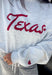 Show your Texas pride in the coziest way possible! This ash grey mock neck sweatshirt blends everyday comfort with timeless style, featuring "Texas" in soft script across the chest and a sweet heart detail on the sleeve. The fleece-lined interior keeps you warm and cozy, while the classic silhouette makes it an easy favorite for everything from football Saturdays and coffee runs to relaxed weekends at home. 