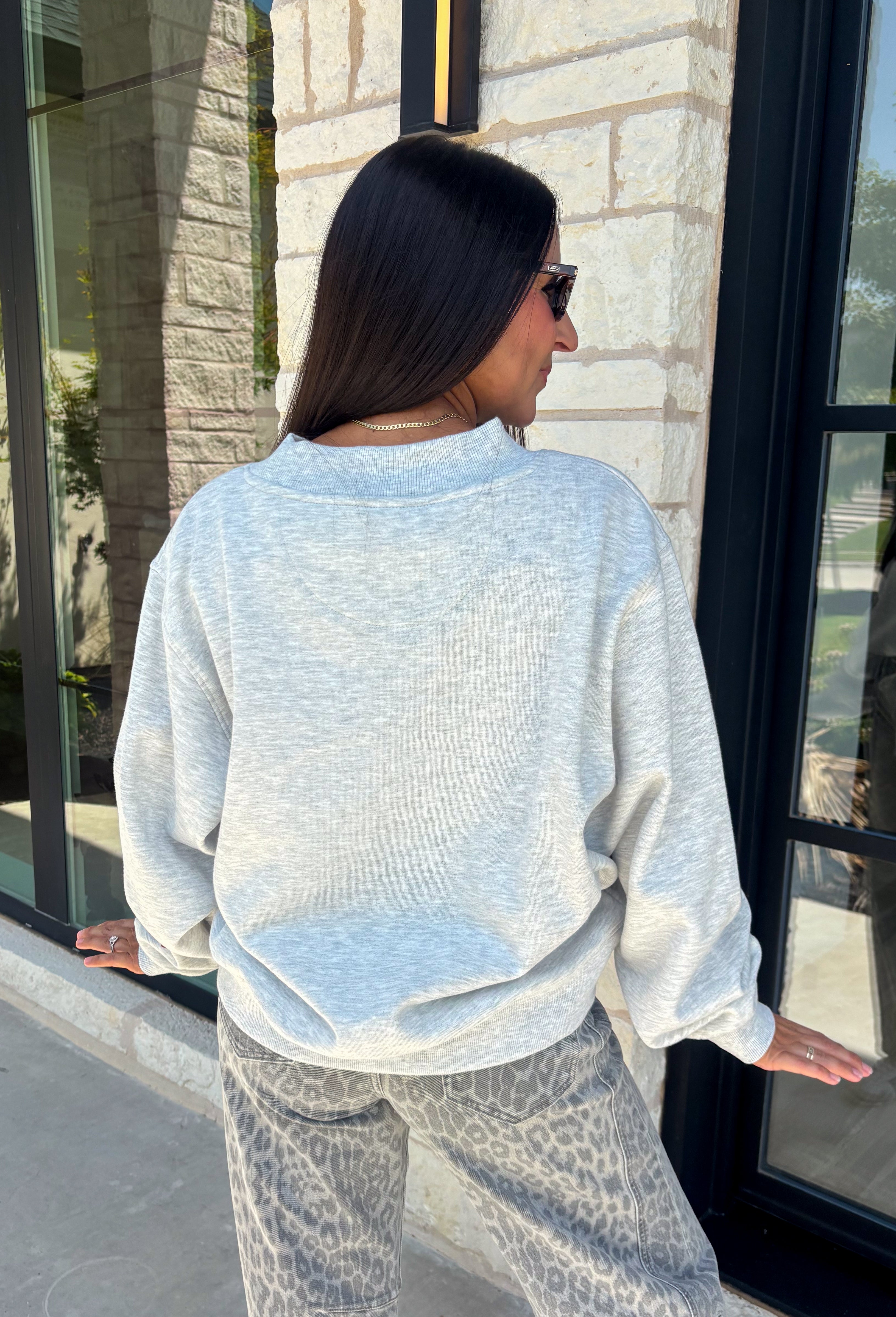 Show your Texas pride in the coziest way possible! This ash grey mock neck sweatshirt blends everyday comfort with timeless style, featuring "Texas" in soft script across the chest and a sweet heart detail on the sleeve. The fleece-lined interior keeps you warm and cozy, while the classic silhouette makes it an easy favorite for everything from football Saturdays and coffee runs to relaxed weekends at home. 