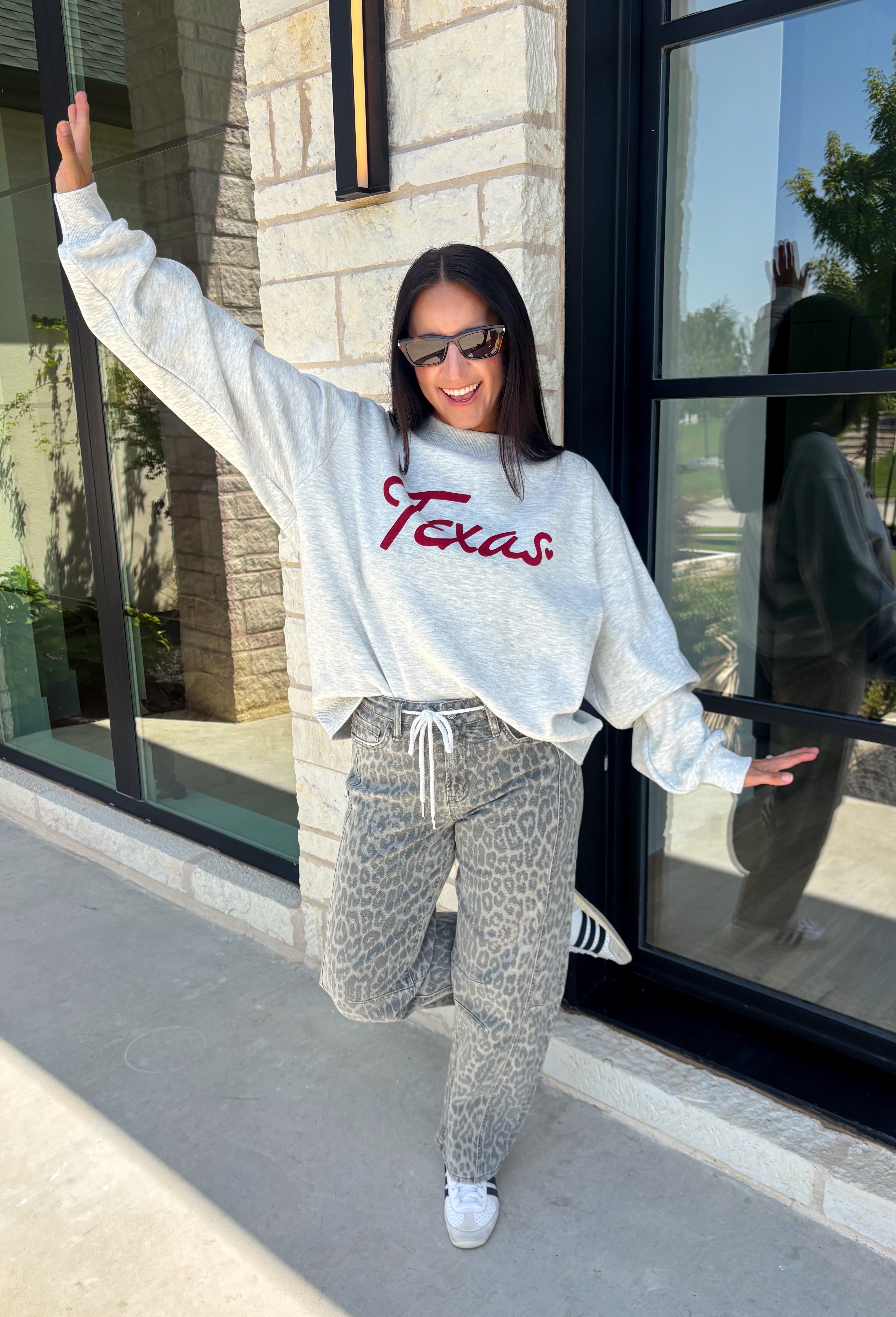 Show your Texas pride in the coziest way possible! This ash grey mock neck sweatshirt blends everyday comfort with timeless style, featuring "Texas" in soft script across the chest and a sweet heart detail on the sleeve. The fleece-lined interior keeps you warm and cozy, while the classic silhouette makes it an easy favorite for everything from football Saturdays and coffee runs to relaxed weekends at home. 