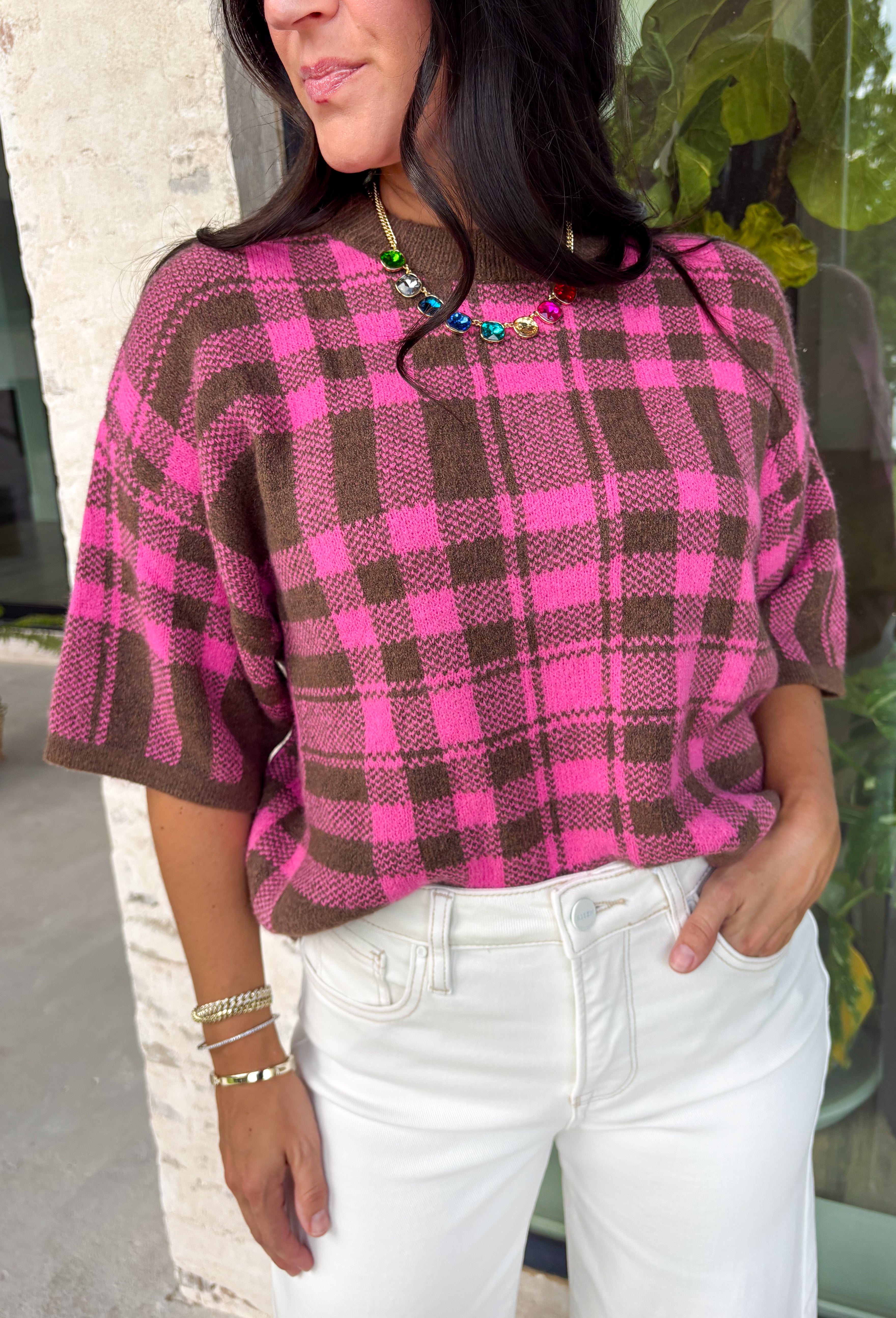 Add a cozy pop of pattern to your everyday wardrobe with this charming sweater from Entro. Designed in a pink and brown plaid knit, this short sleeve sweater is the perfect blend of classic style and seasonal warmth. The soft, cozy knit makes it comfortable enough for all-day wear, while the timeless plaid pattern adds effortless charm to any outfit. 