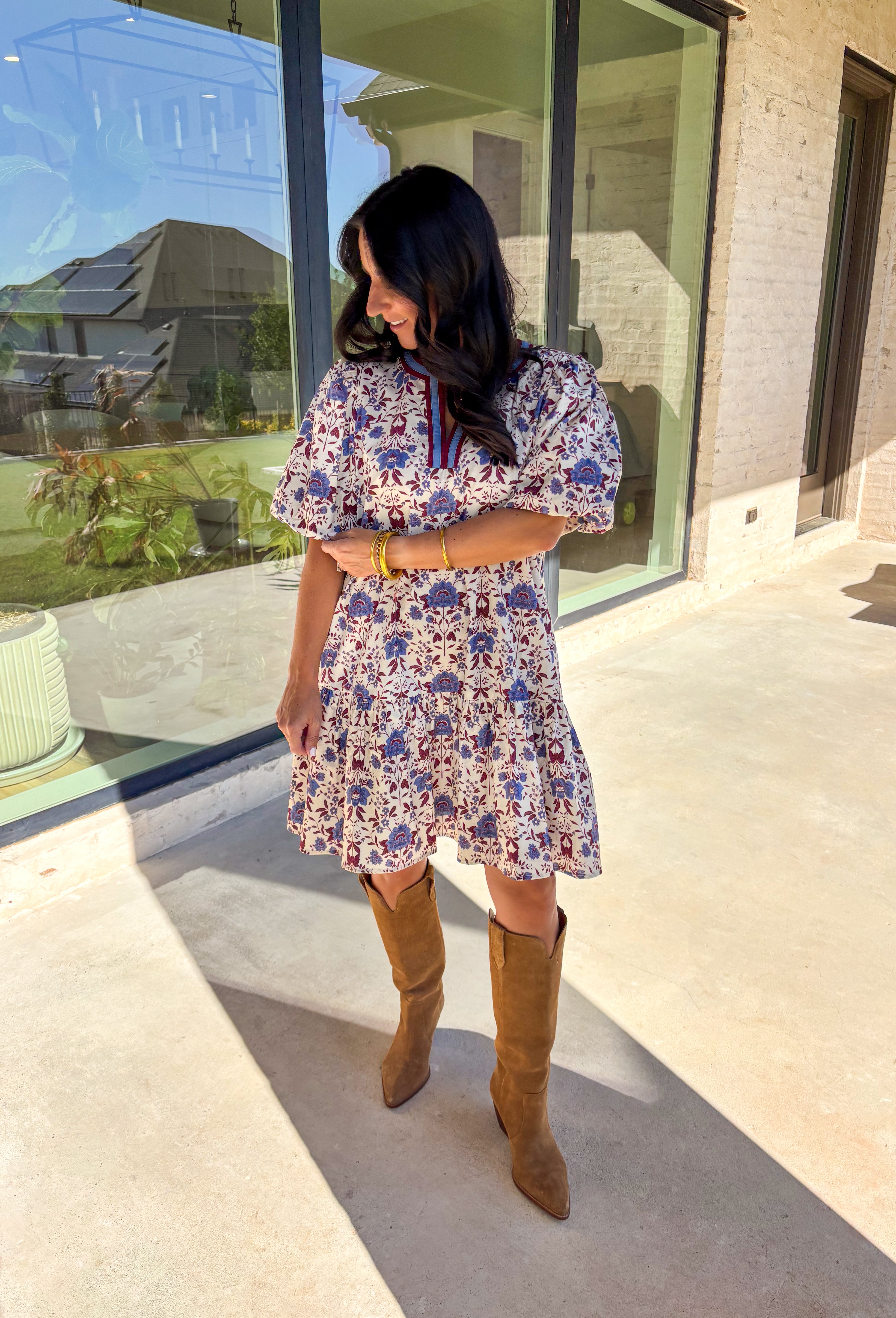 Romantic florals meet cozy charm in this cream short sleeve dress. Designed with shades of burgundy and blue for an autumn-inspired palette, it features a botanical print and contrast binding along the v-neckline for a polished finish. The puff sleeves add a playful touch, while the ruffle hem brings soft movement. Fully lined with side pockets for practicality, this dress is as easy to wear as it is beautiful.